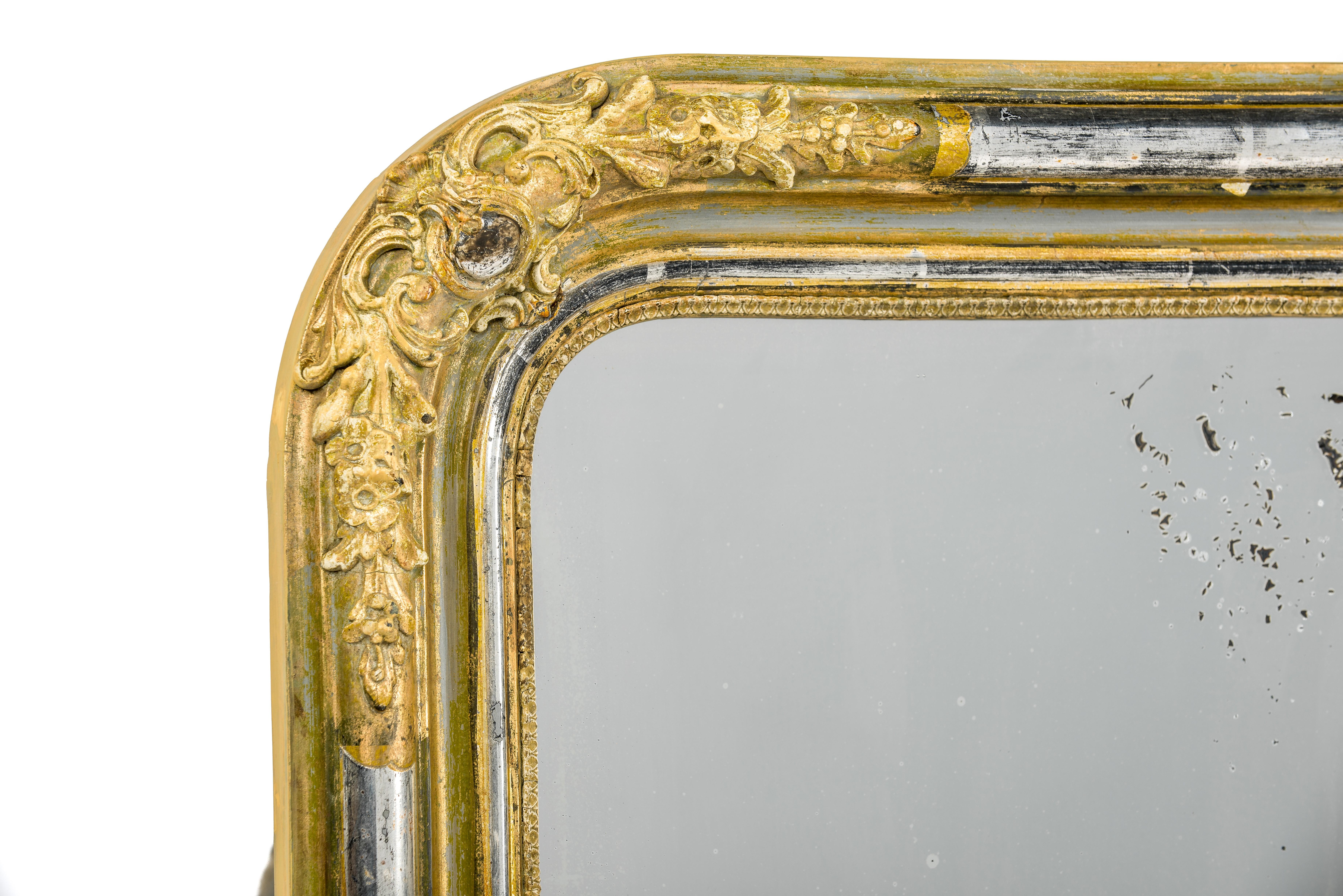 This elegant mirror was made in northern France, in the Alsace Lorraine region in circa 1880. The frame has the upper rounded corners typical for the Louis Philippe style. It features rich and highly detailed ornaments on all corners of the frame,