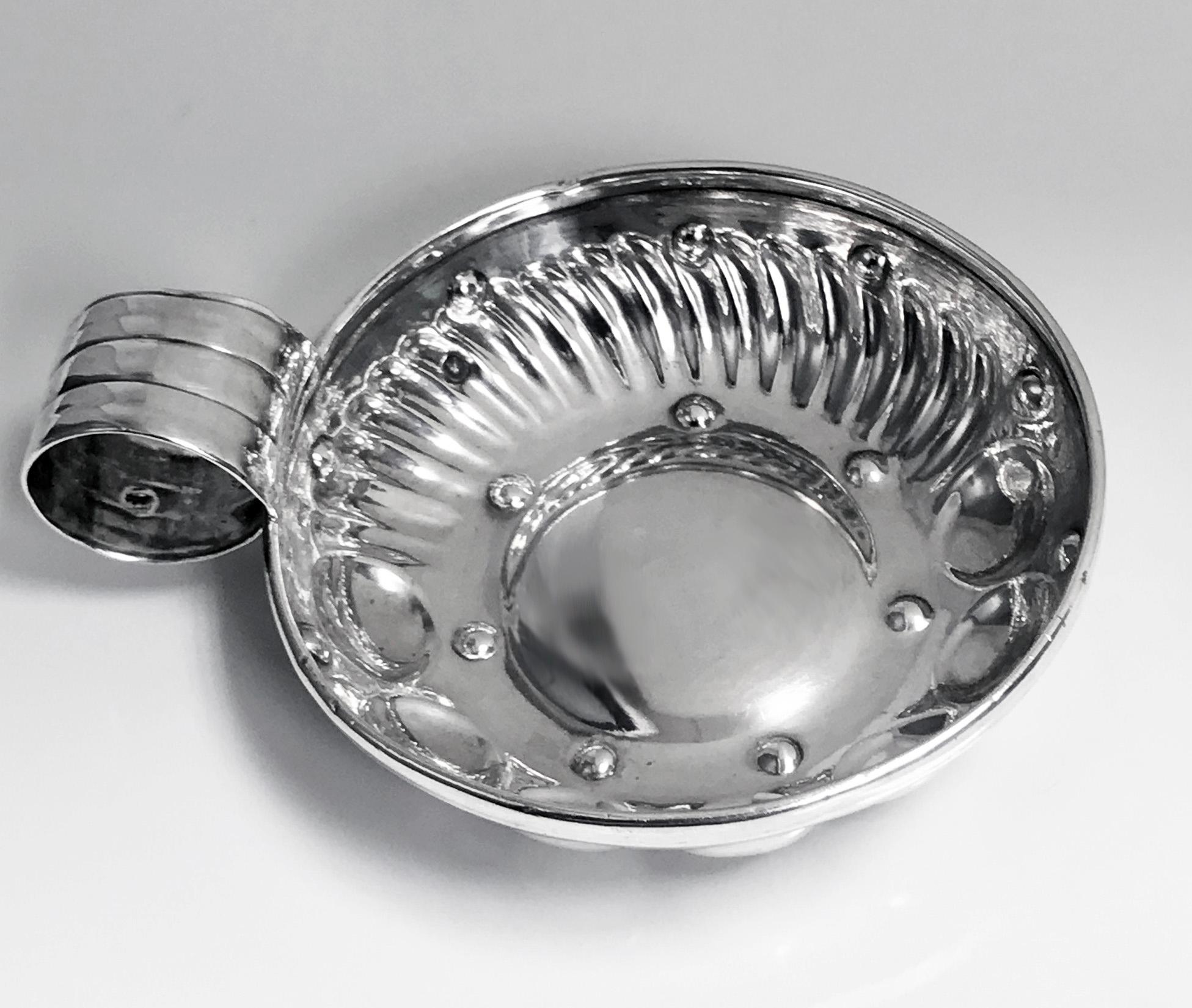 Antique French silver tastevin circa 1880, CT for Cesar Tonnelier, Minerva head 1st std. The test de vin of usual form, the lower part of bowl with a surround of concave and swirl lobate style decoration, ribbed thumb piece handle. Marked on handle
