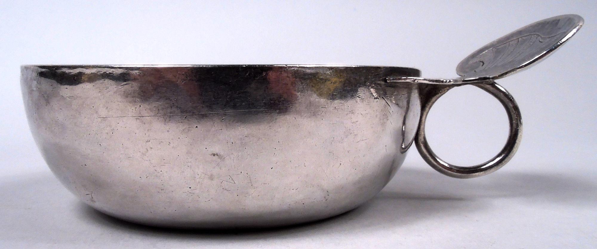 Catador de vino francés de plata, siglo XVIII. El cuenco tiene los lados curvados; asa anular con apoyo para el pulgar en forma de concha de vieira grabada. Nombre inciso 