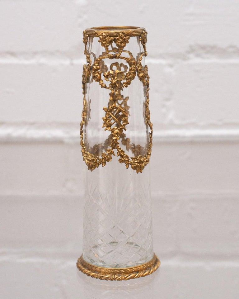 A small delicate antique French cut crystal vase with ormolu wreaths. Exceptionally detailed and finely made, this small piece has a big impact.