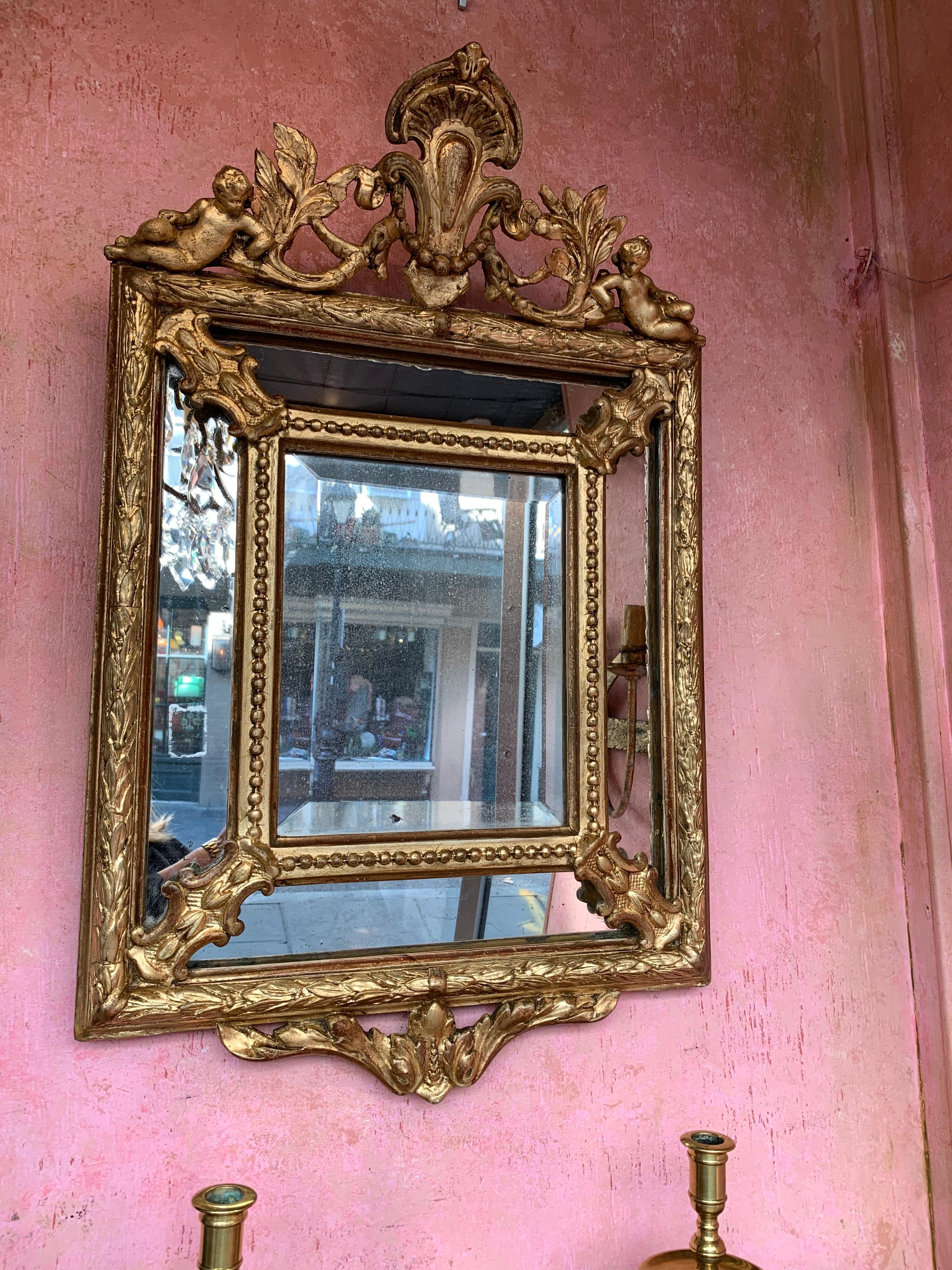 Antique French small giltwood mirror with cherubs.