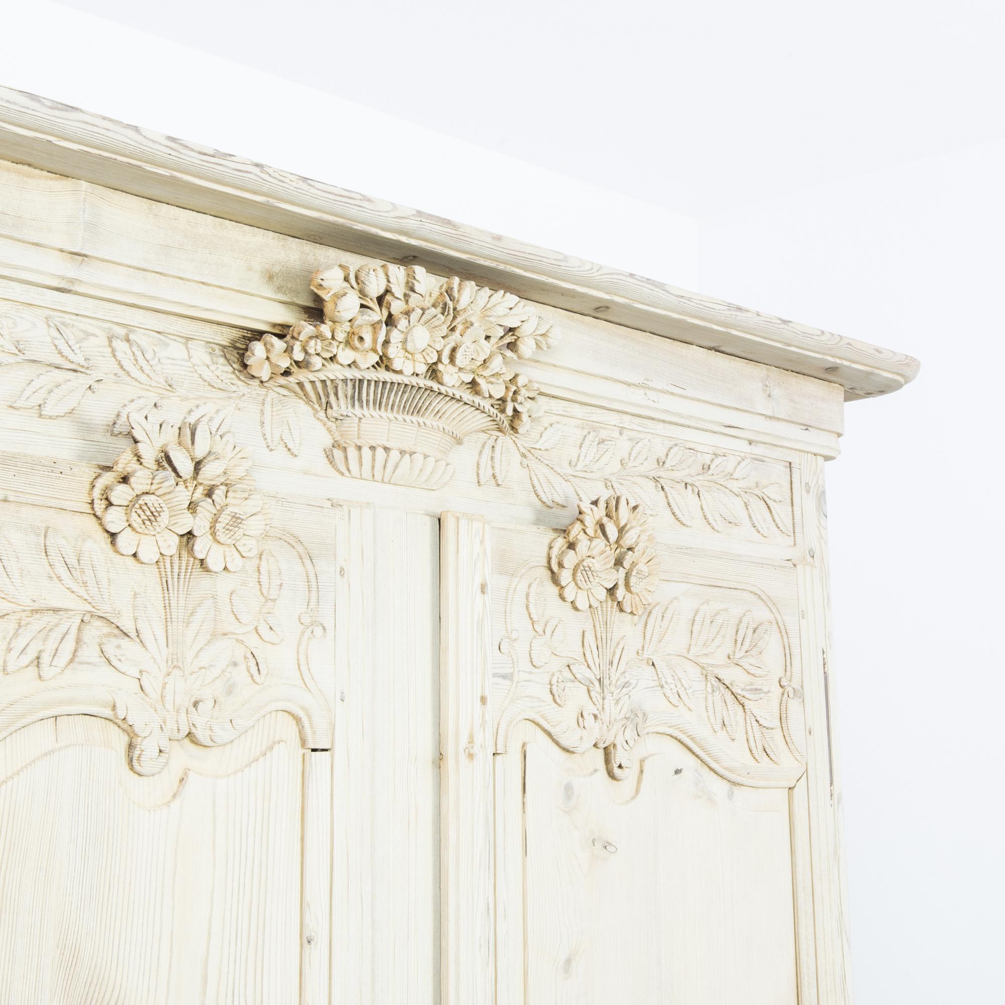 This wooden armoire made in France offers an old-world, rustic charm. With the elegantly contoured panels and the finely carved bouquets of flowers and leaves, the armoire is an impressive showcase of high-quality craftsmanship. The double doors,