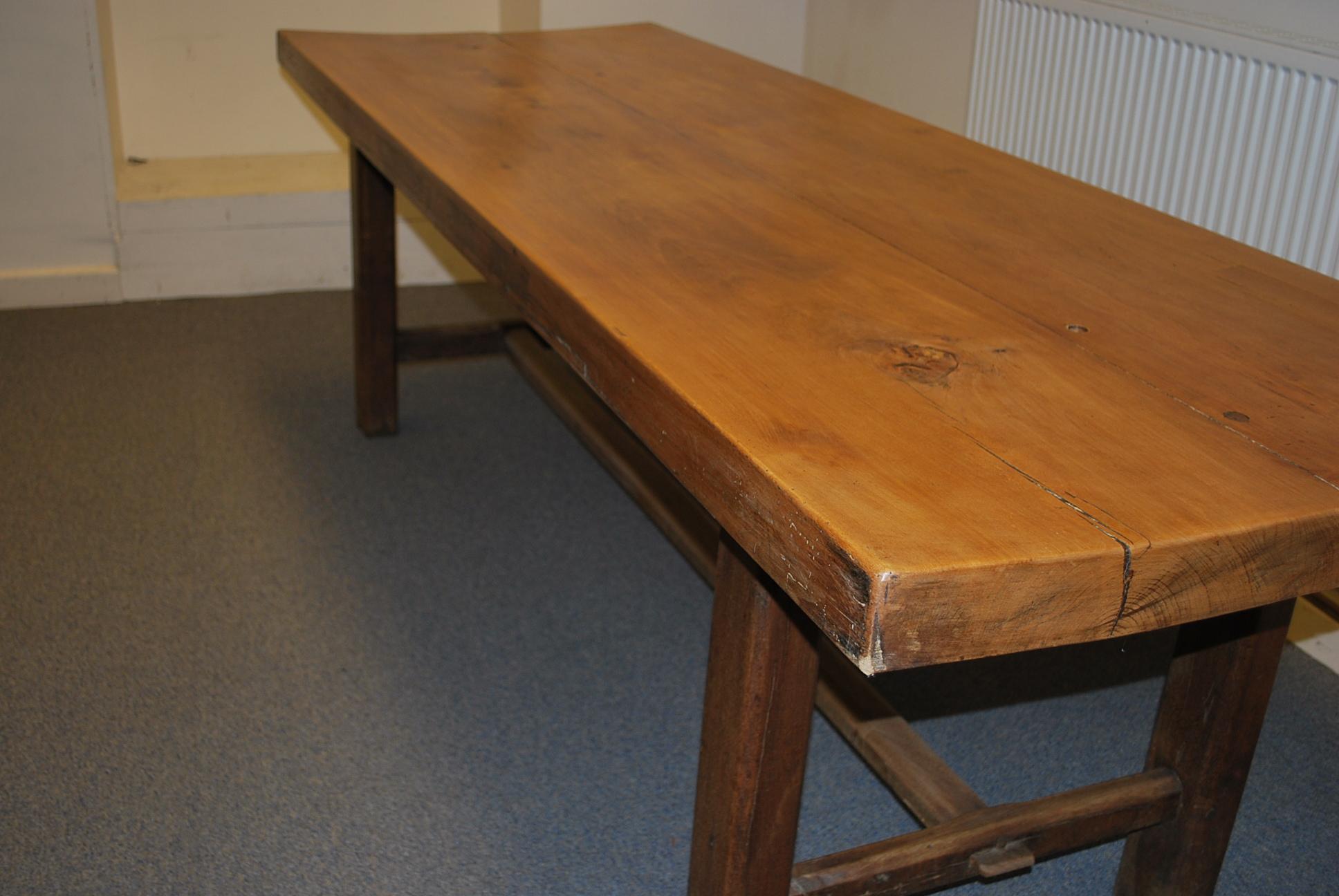 A large thick top elm French farmhouse table, standing on chamfered legs united by a 'H' stretcher. Made from only two pieces and in Elm. Excellent legroom all the way around . A very good example of its kind. Leg height 70 cm.