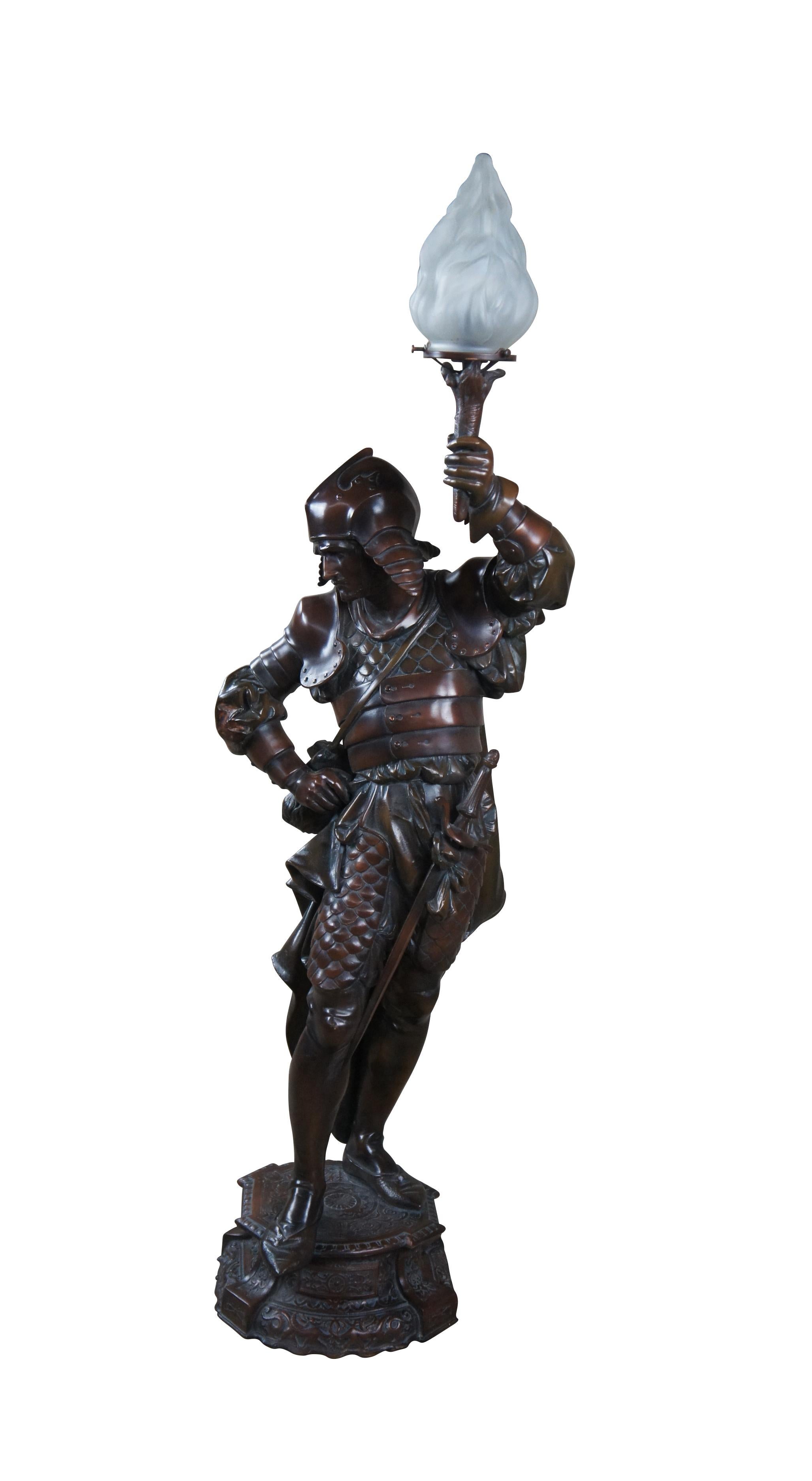 A large French early 20th century Newel Post or Floor Lamp.  Features a bronzed spelter figure in the form of a 16th century warrior or knight in full armour and draped cloaks with flambeau shade.

The  warrior is holding a torch with opaque
