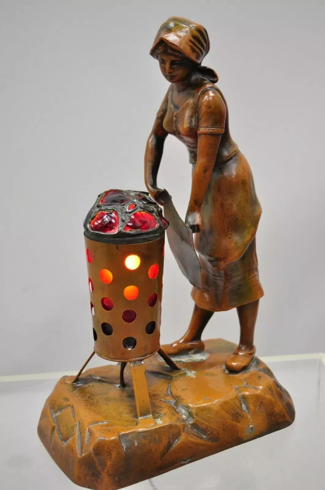  Antique French Spelter Metal Figural Woman by Coal Fire Statue Lamp attribuito a Raineri. L'oggetto presenta una cornice in metallo spelta dipinta a freddo, forse di A.de Ranieri. Circa all'inizio del XX secolo. Misure: 13