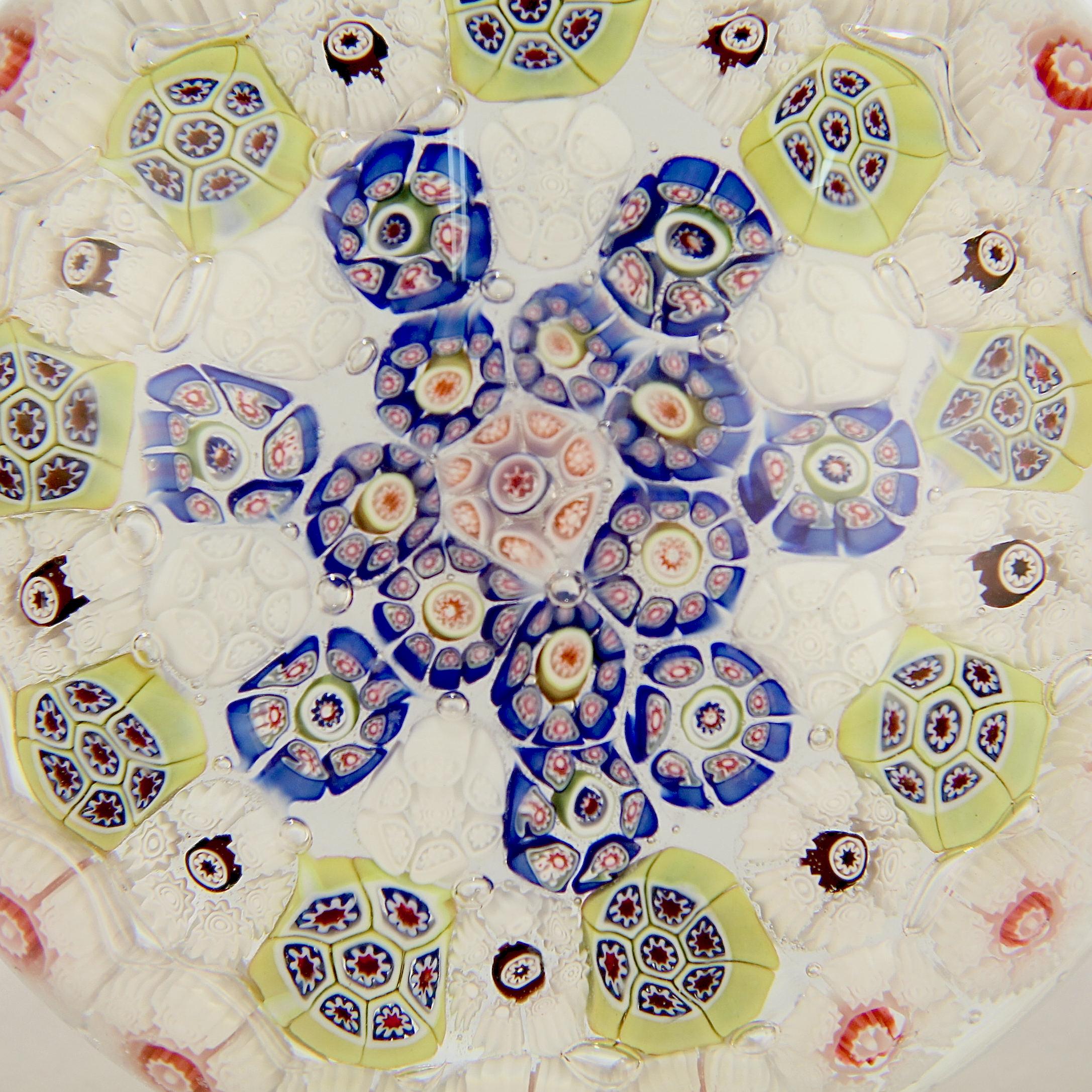 A very fine St. Louis or Baccarat Millefiori art glass paperweight

It has multiple concentric circles of millefiori canes with principally white tones and primary color accents.

The base has a concave polished pontil.

Simply a lovely