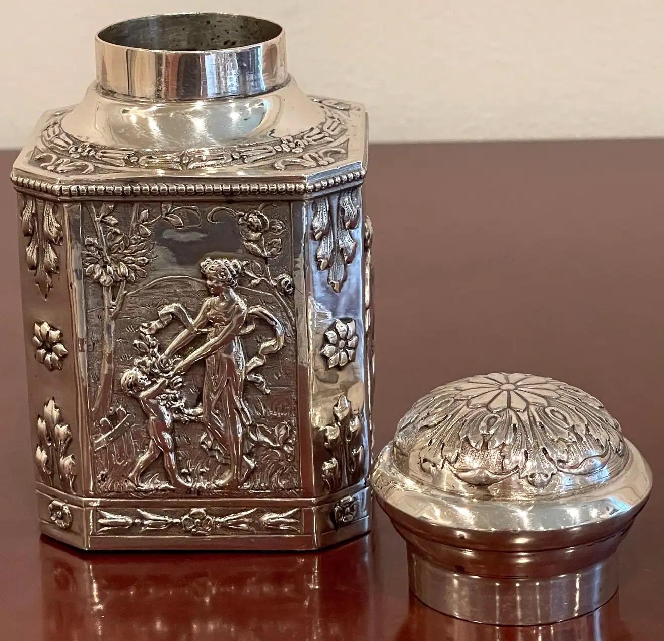 Antique French Sterling neoclassical 'Four Seasons' tea caddy
France, circa 1880s

A hefty, highly detailed silver tea caddy/ box, with removable acanthus/ floret motif circular lid, resting on a squared hexagonal base, each side representing the