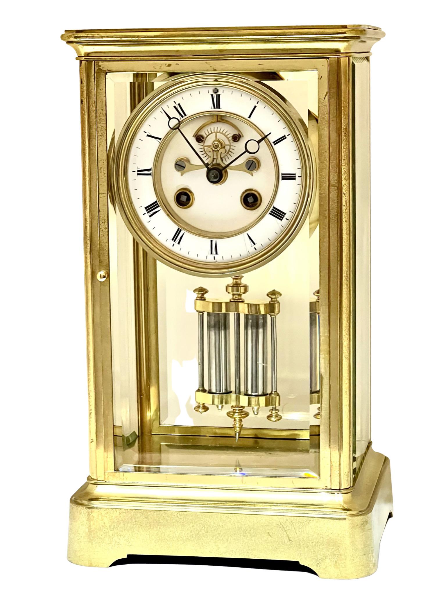 A handsome and stylish antique French brass striking four glass mantel clock. The visible Brocot escapement to the fine two piece white enamel dial is an attractive feature, as well as the twin sealed mercury jar pendulum.

It has an attractive