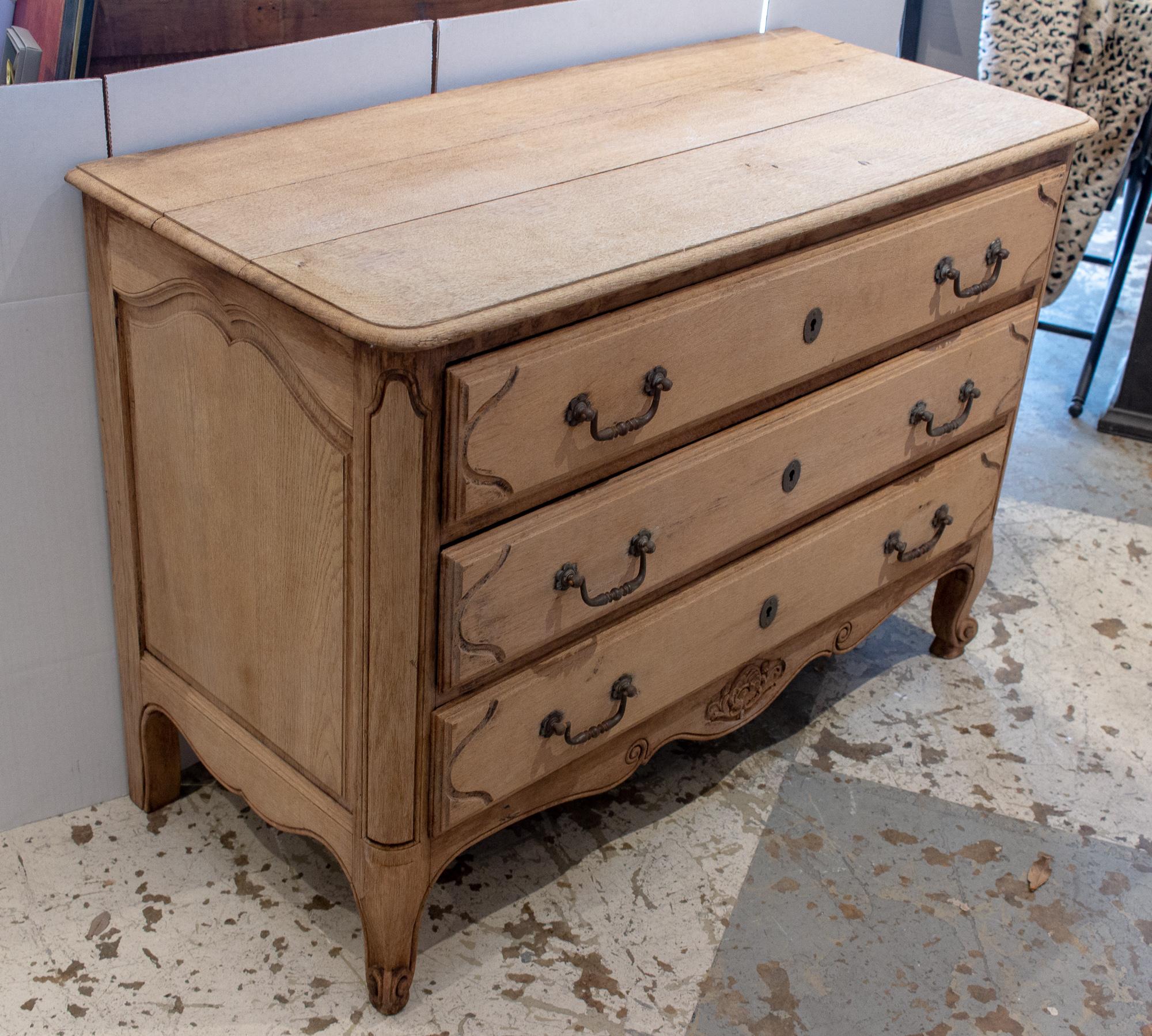 This stripped wood commode dates to the early 20th century, and features wonderful carved details in the edges, legs, drawer fronts and the lower skirt and legs. With three ample drawers, this piece would allow plenty of storage, or could be