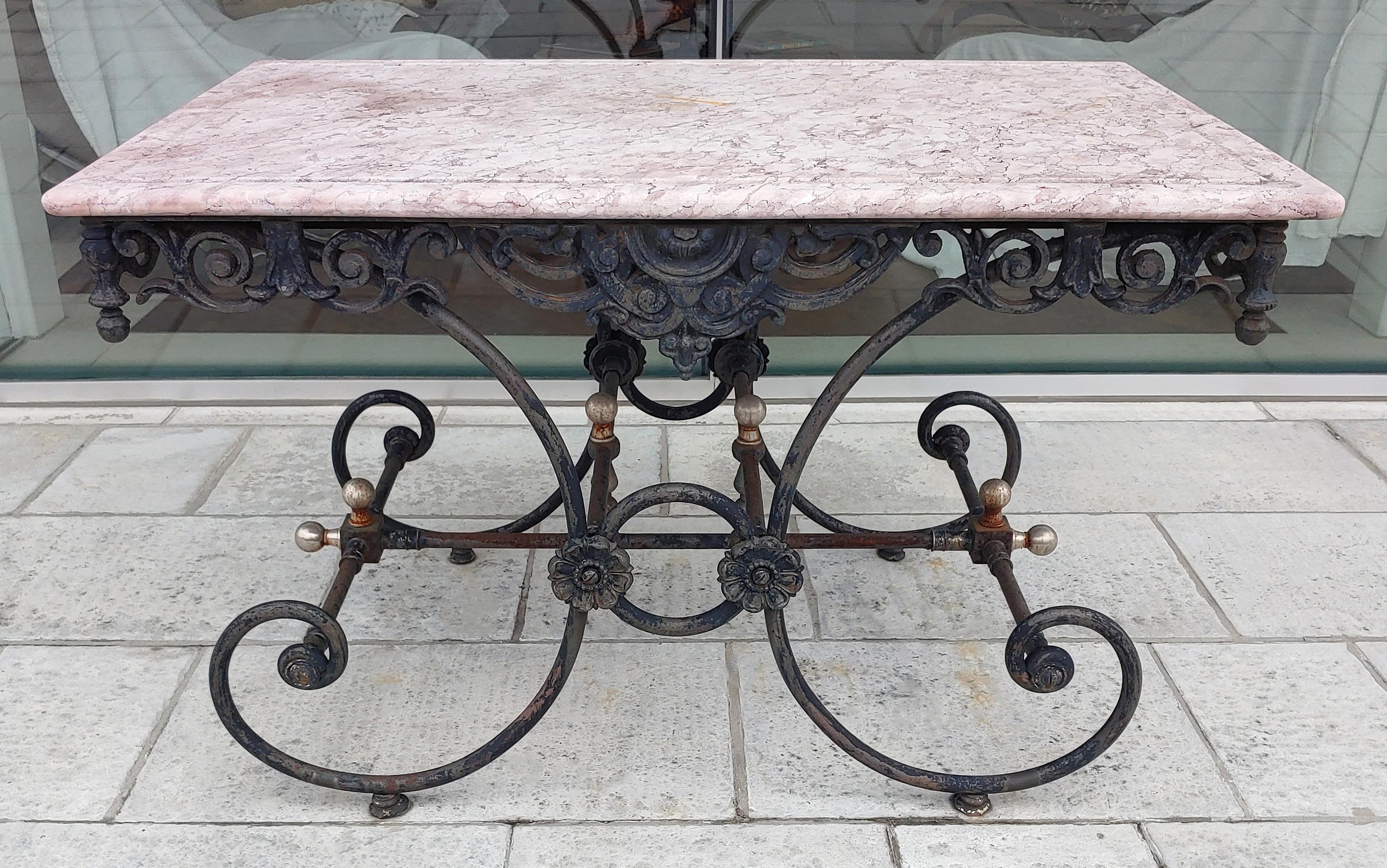 For your consideration is a lovely, antique French style wrought iron, indoor outdoor bistro table, with a pink stone top. In very good vintage condition. The dimensions are 48.25