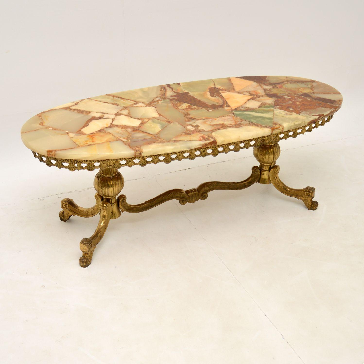A beautiful and striking antique French style coffee table. This was made in France or Italy and dates from the 1950’s.

The quality is excellent, with a very well made solid brass frame. The loose onyx top is stunning and is made from a patchwork