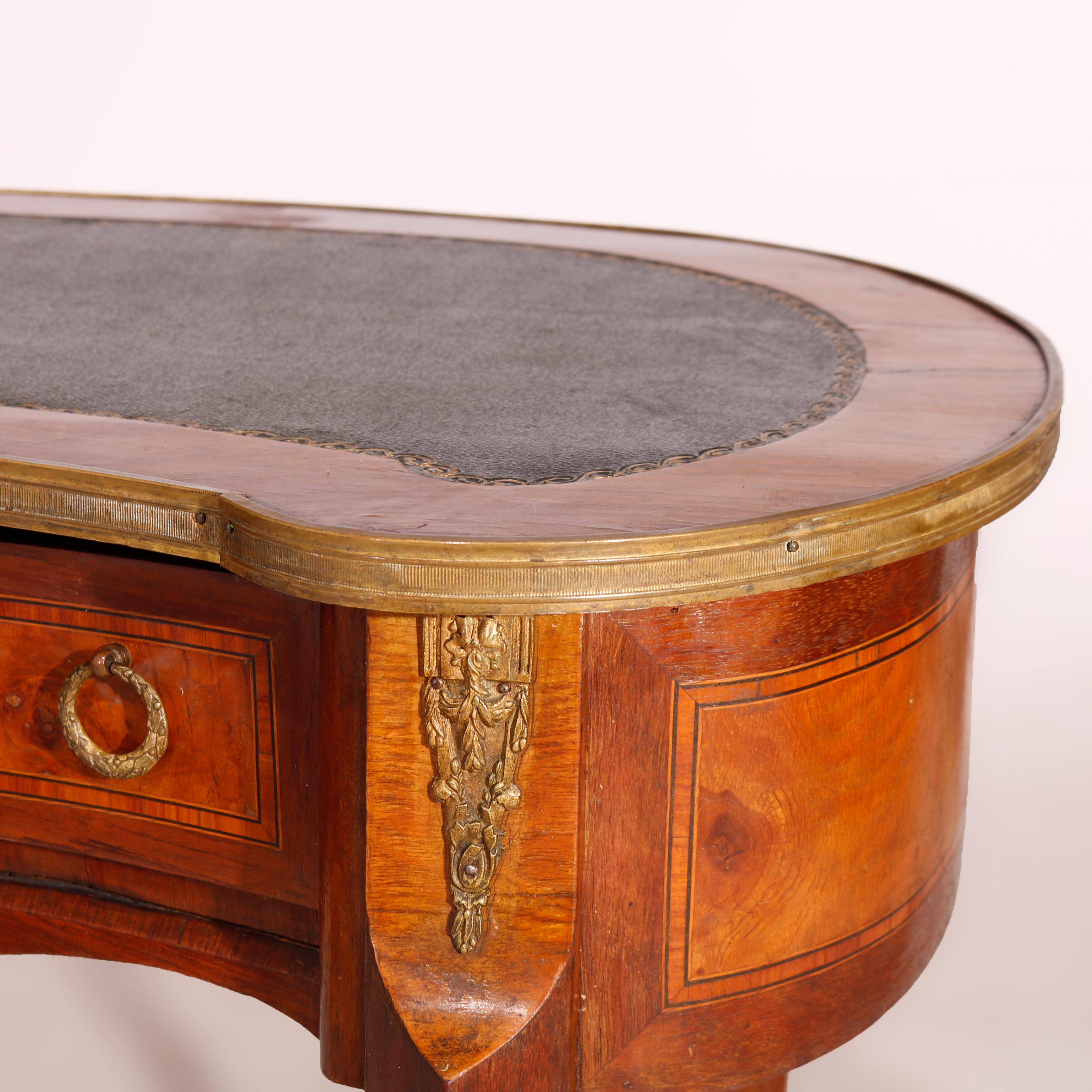 An antique French ladies desk offers walnut and burl construction in kidney form with gilt decorated leather top over case with single drawer, cast ormolu mounts throughout, raised on cabriole legs, 19th century.

Measures - 30.5