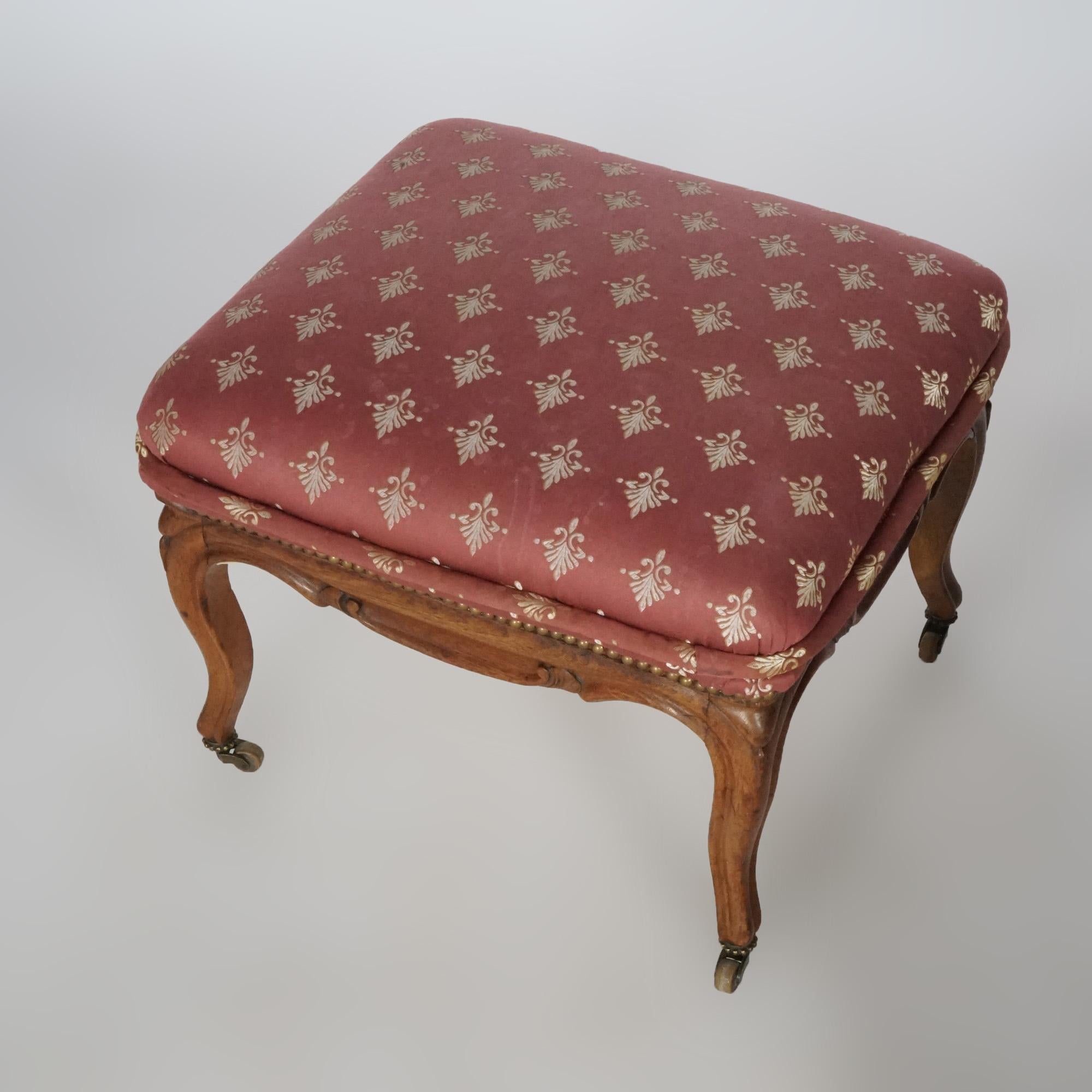 An antique French style footstool offers upholstered seat over walnut base having carved skirt and cabriole legs, circa 1920.

Measures- 18'' H x 23'' W x 21.5'' D.