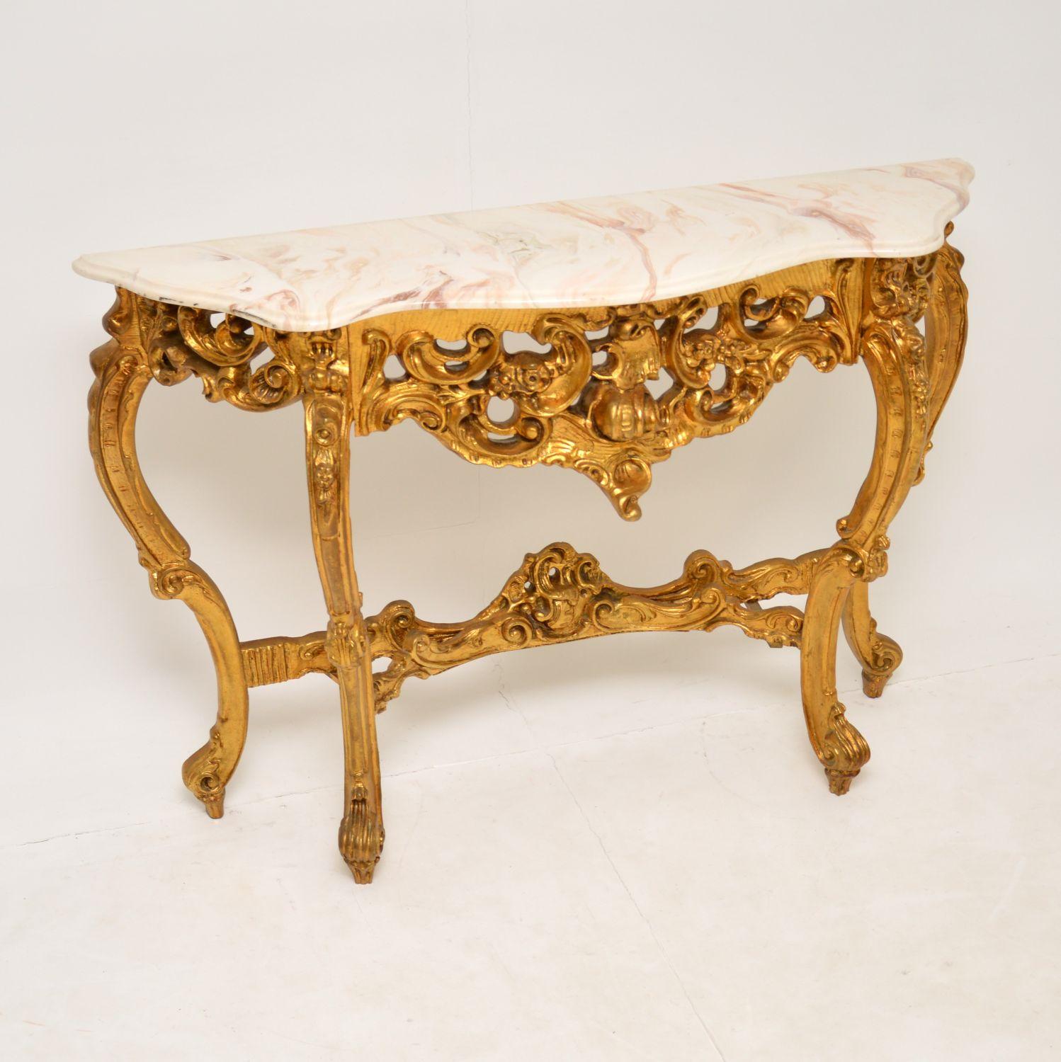 A beautiful gilt wood console table, in the antique French rococo style. This dates from around the 1950-60’s.

It is very well made and is in excellent condition for its age. The white composite marble top is clean and damage free, with beautiful