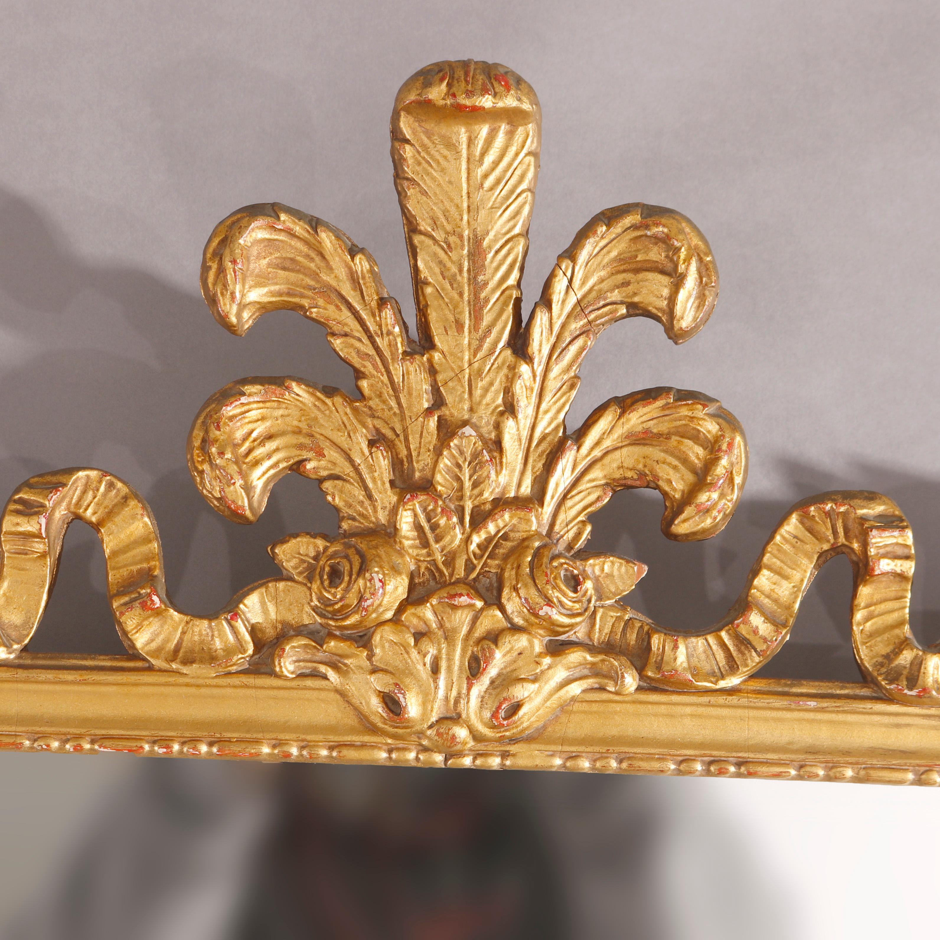 An antique French style wall mirror offers giltwood construction with fleur de lis crest over frame with foliate and scroll elements, c1920

Measures - 34