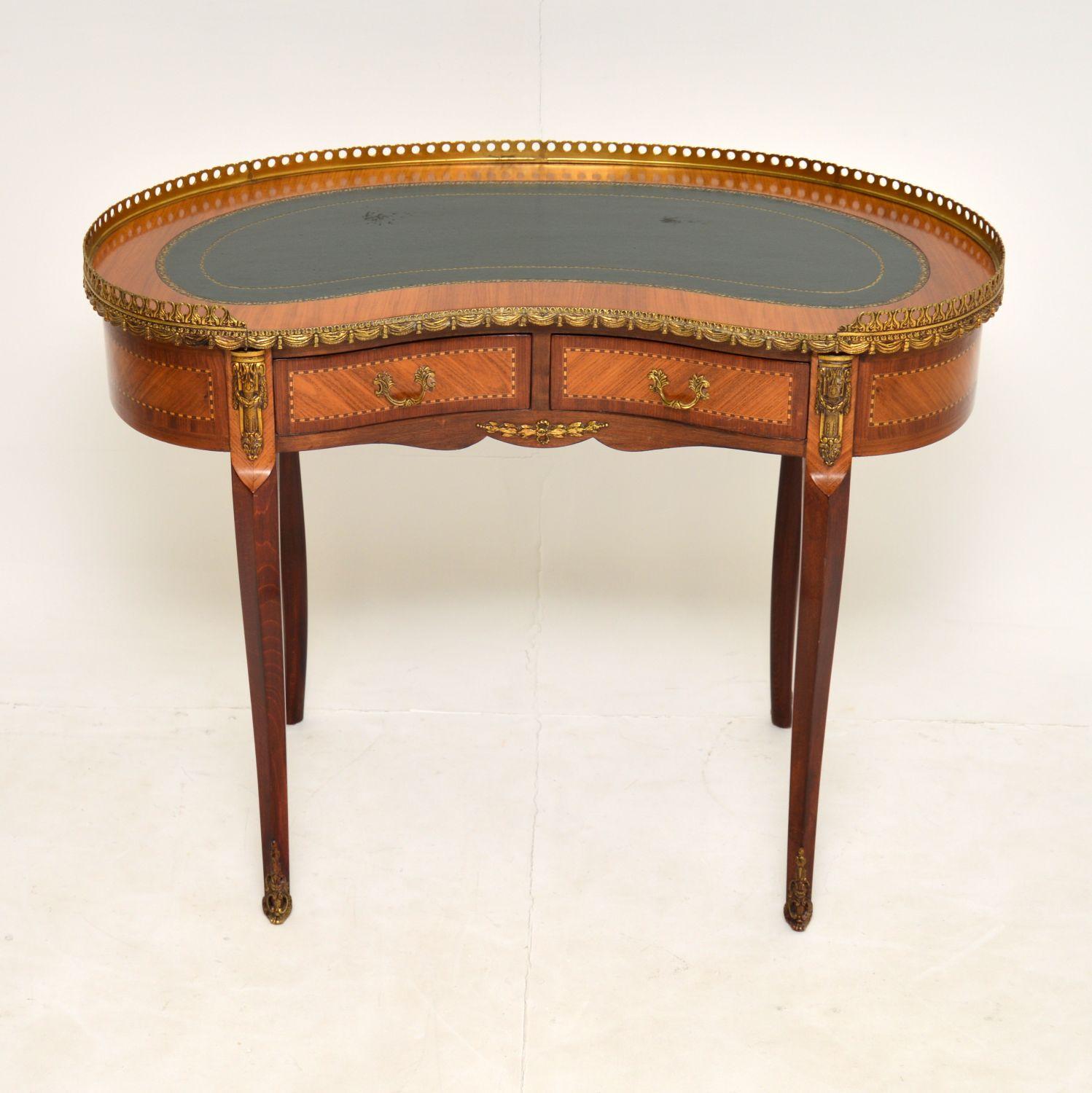 A stunning antique French style kidney shaped desk, dating from around the 1930’s period.

It is of fabulous quality, with a mahogany construction and contrasting veneers of mahogany, Kingwood and satin wood. There are fine gilt bronze mounts