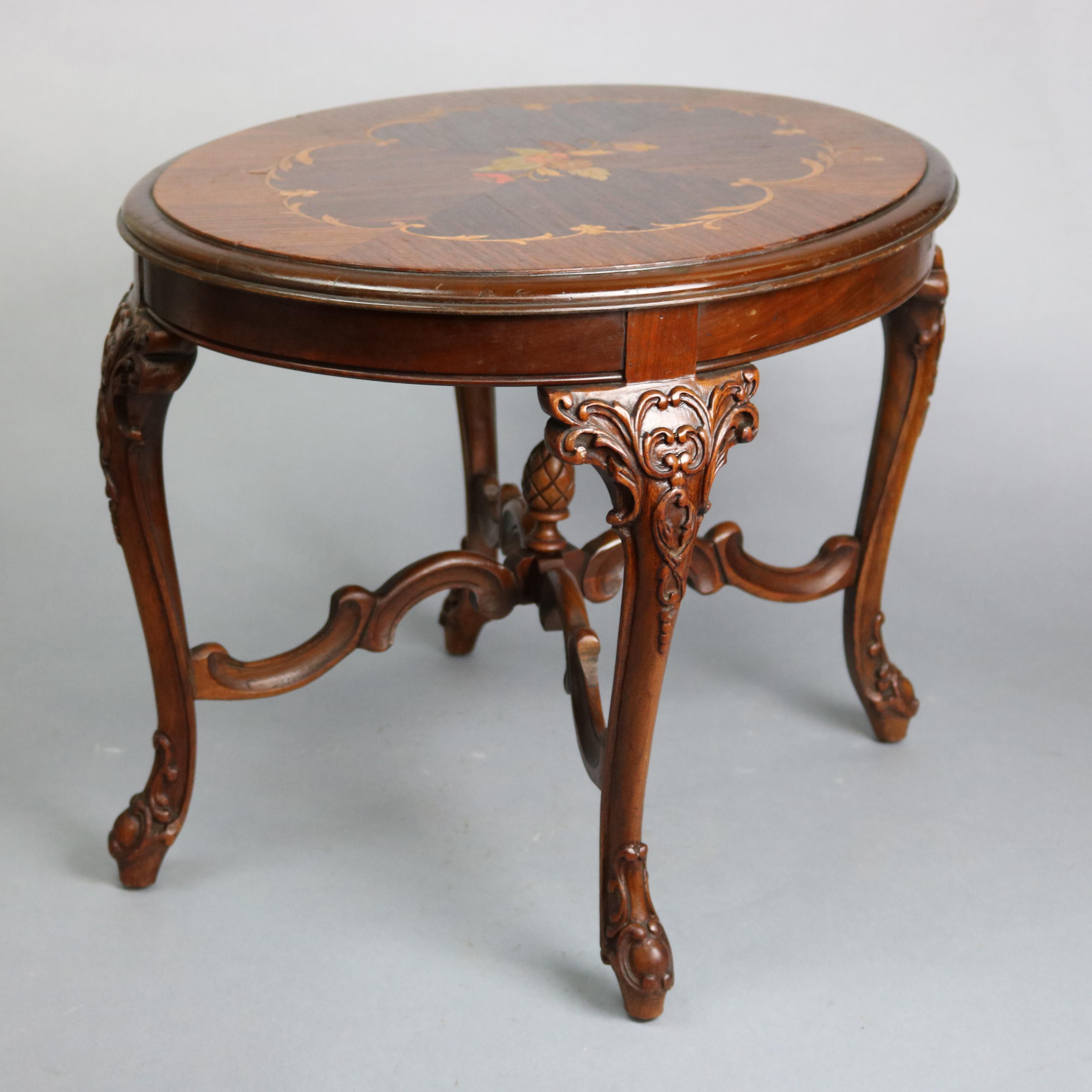 An antique French style side table offers mahogany construction with kingwood inlaid foliate marquetry top surmounting mahogany base having foliate carved cabriole legs with scroll form cross stretcher and central finial, circa 1920

Measures: 18