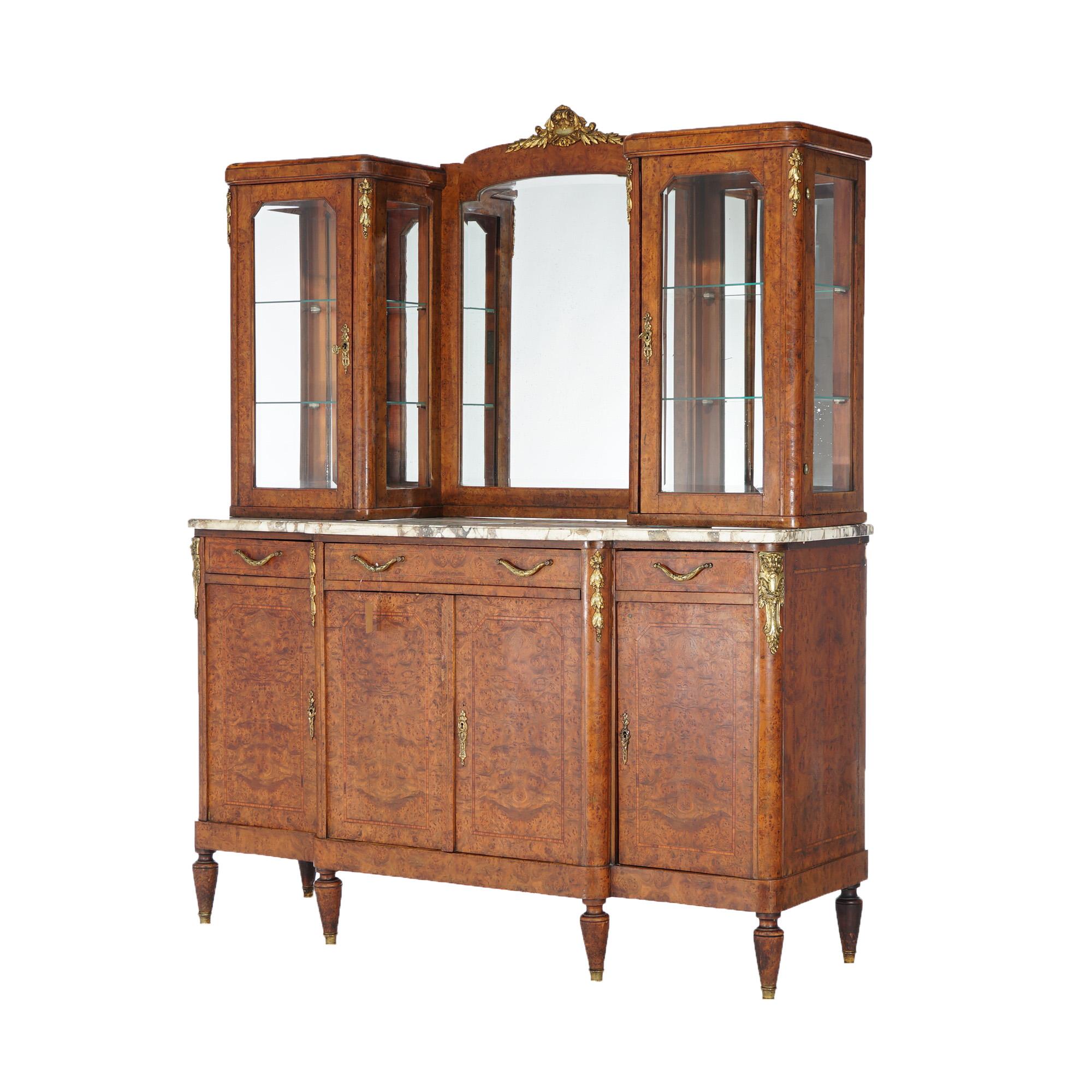 An antique French style buffet offers burl construction with mirrored upper having flanking glass display cabinets over marble base with lower blind door cabinets, inlaid banding and gilt cast mounts throughout, raised on tapered turned legs,