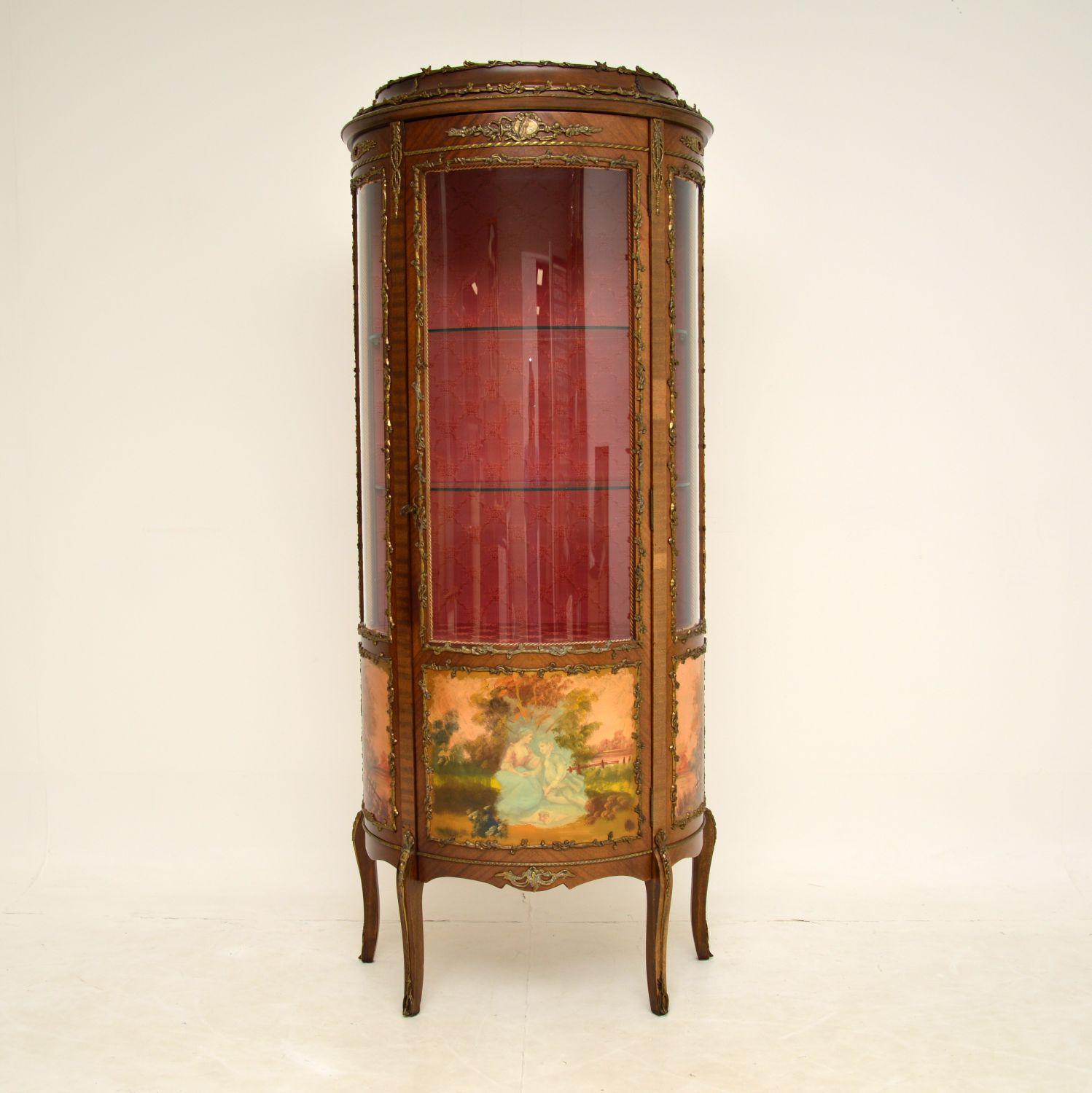 A stunning painted and ormolu mounted antique French style display cabinet, which we would dates from around the 1930’s period.

It is of lovely quality, with a finely made curved glass front and sides. The wood has stunning gilt bronze mounts all
