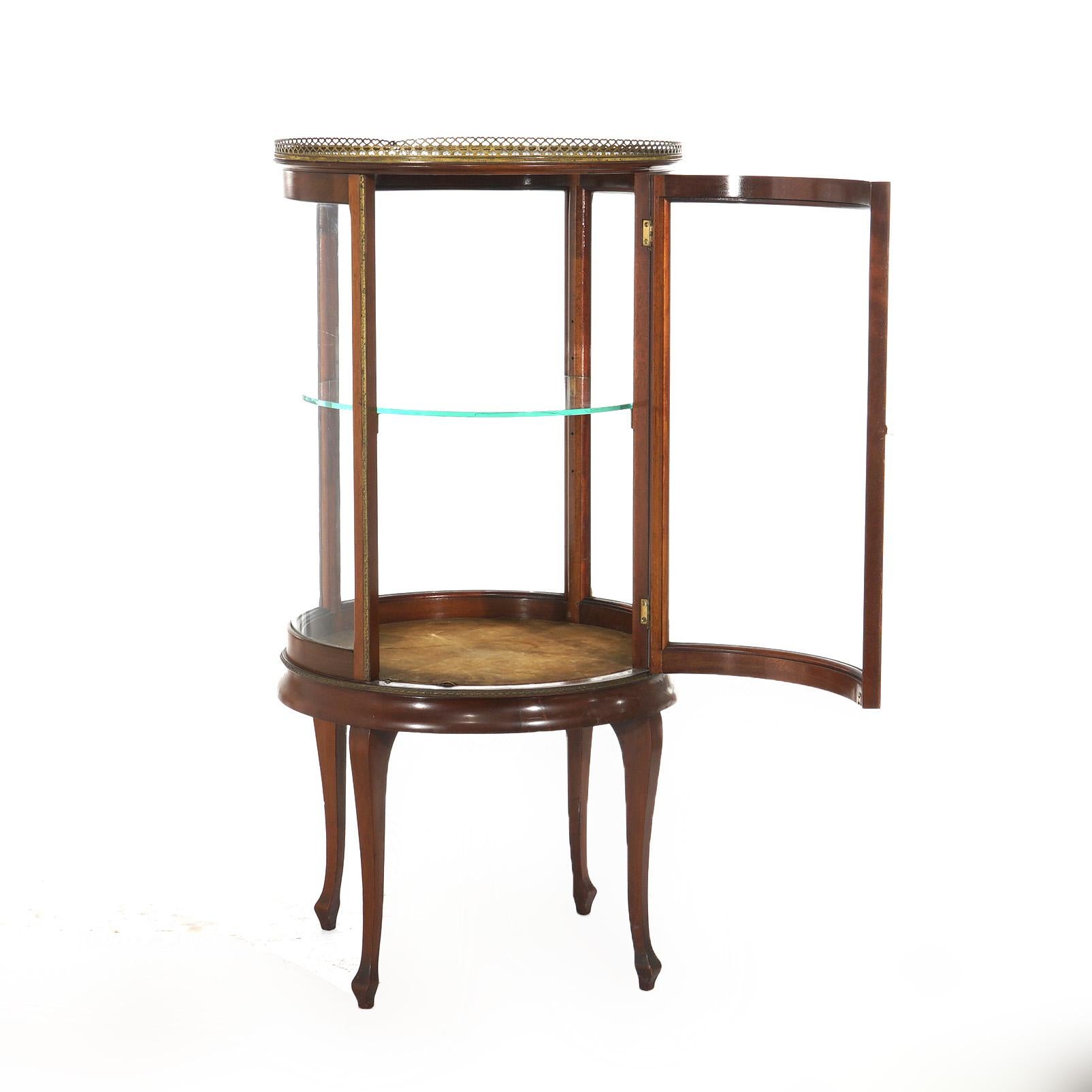 ***Ask About Reduced In-House Shipping Rates - Reliable Service & Fully Insured***
An antique French style circular display vitrine offers mahogany construction with pierced upper gallery over bent glass case having single door opening to shelved