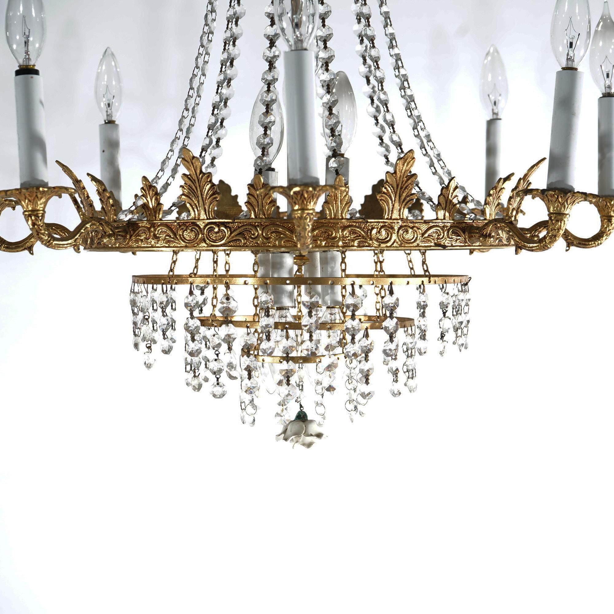 A French style wedding cake chandelier offers gilt metal frame with foliate elements throughout, sixteen scroll form arms terminating in candle lights, and allover cut crystals, c1940

Measures - 29