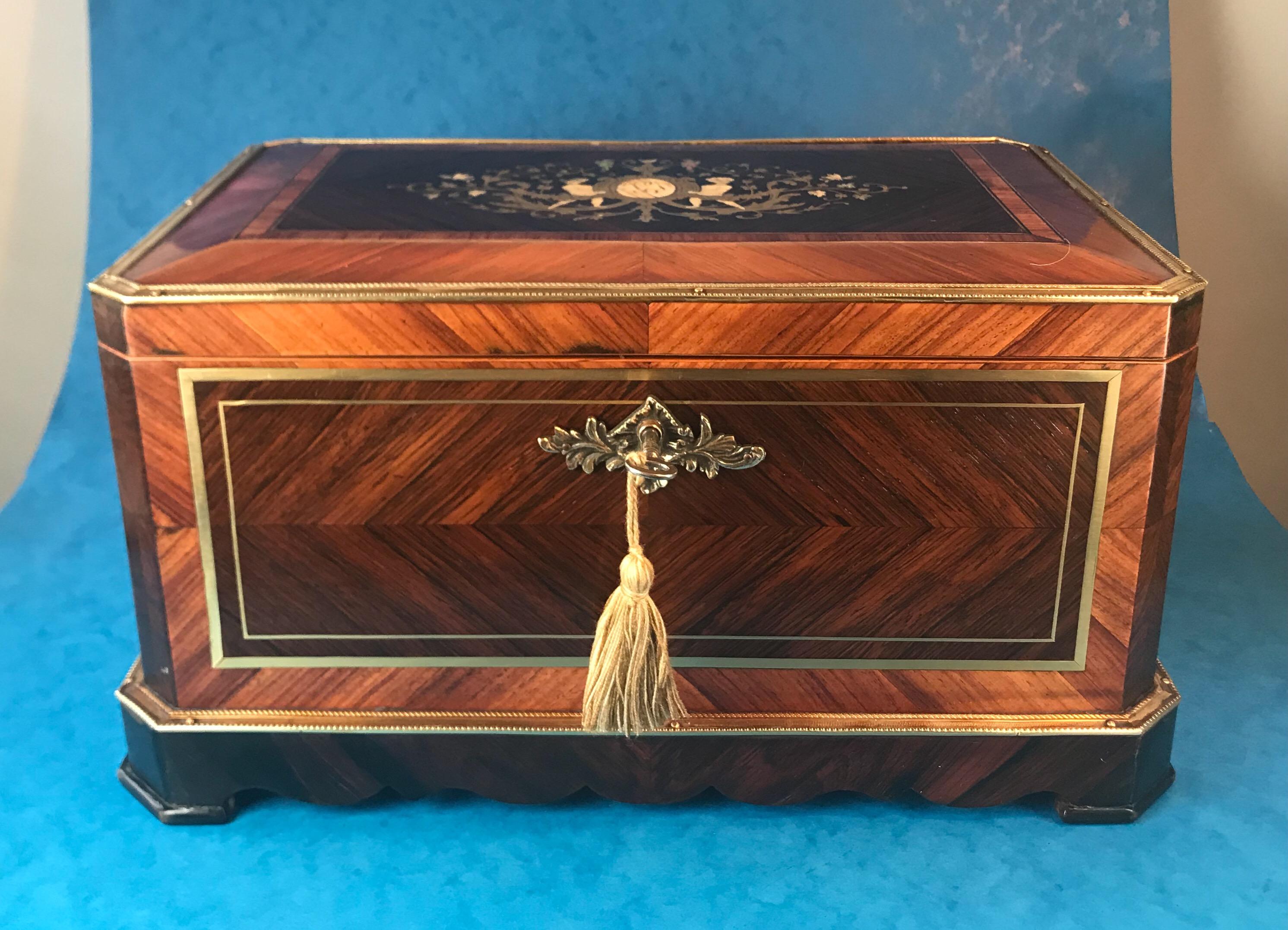 A magnificent Antique French table box. It’s veneered in rosewood, 
the box dates to 1830, its edged in brass and it’s brass and angle cut Tulipwood inlaid. 

The centre of the box it has a beautiful picture of brass inlaid flowers, beaches and