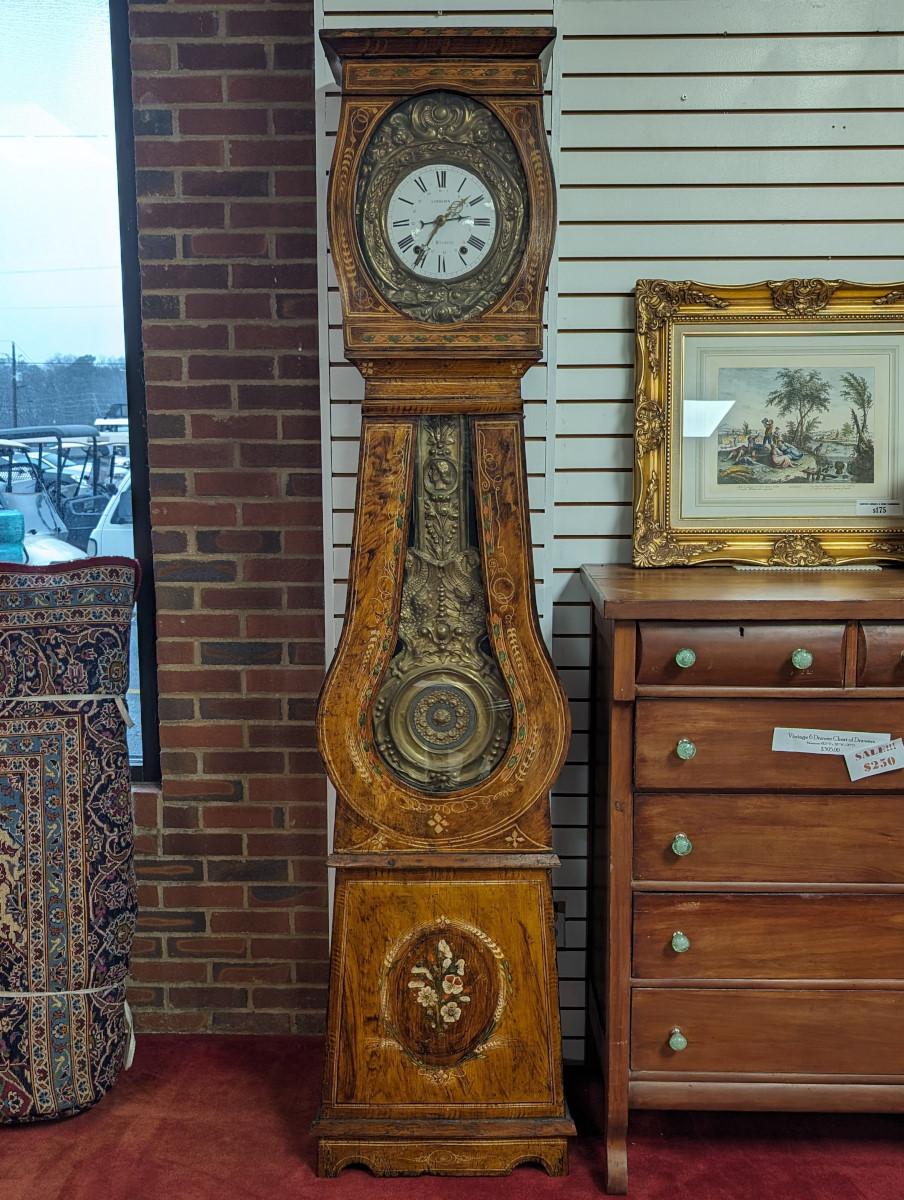 French Case Clock, Tall Case Clock, Grandfather Clock, Circa 1870, Pine case, Painted front, Clock face is framed by an intricate brass repousse frontage, Clock face displays hand painted roman numerals as well as “Langlois, a Montebourg” to