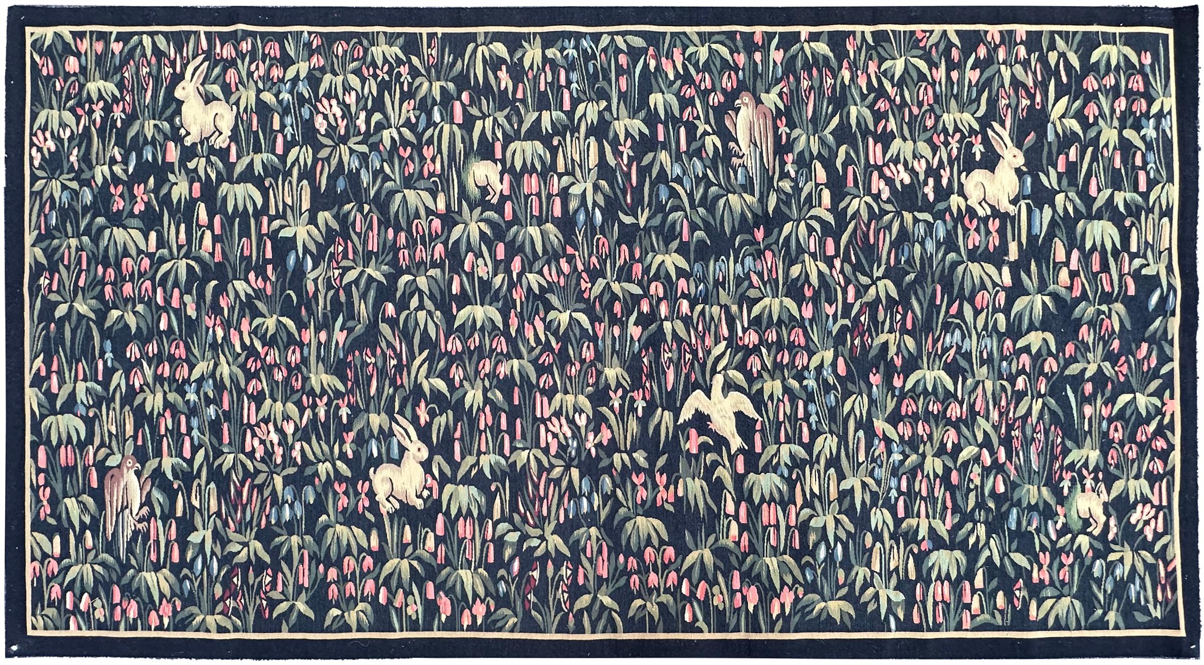 This beautifully woven French Arts 
Crafts tapestry depicts an enchanting wildlife garden filled with birds, rabbits, and dense stylized foliage. Its refined detailing, rich colors, and balanced composition highlight classic early 20th-century