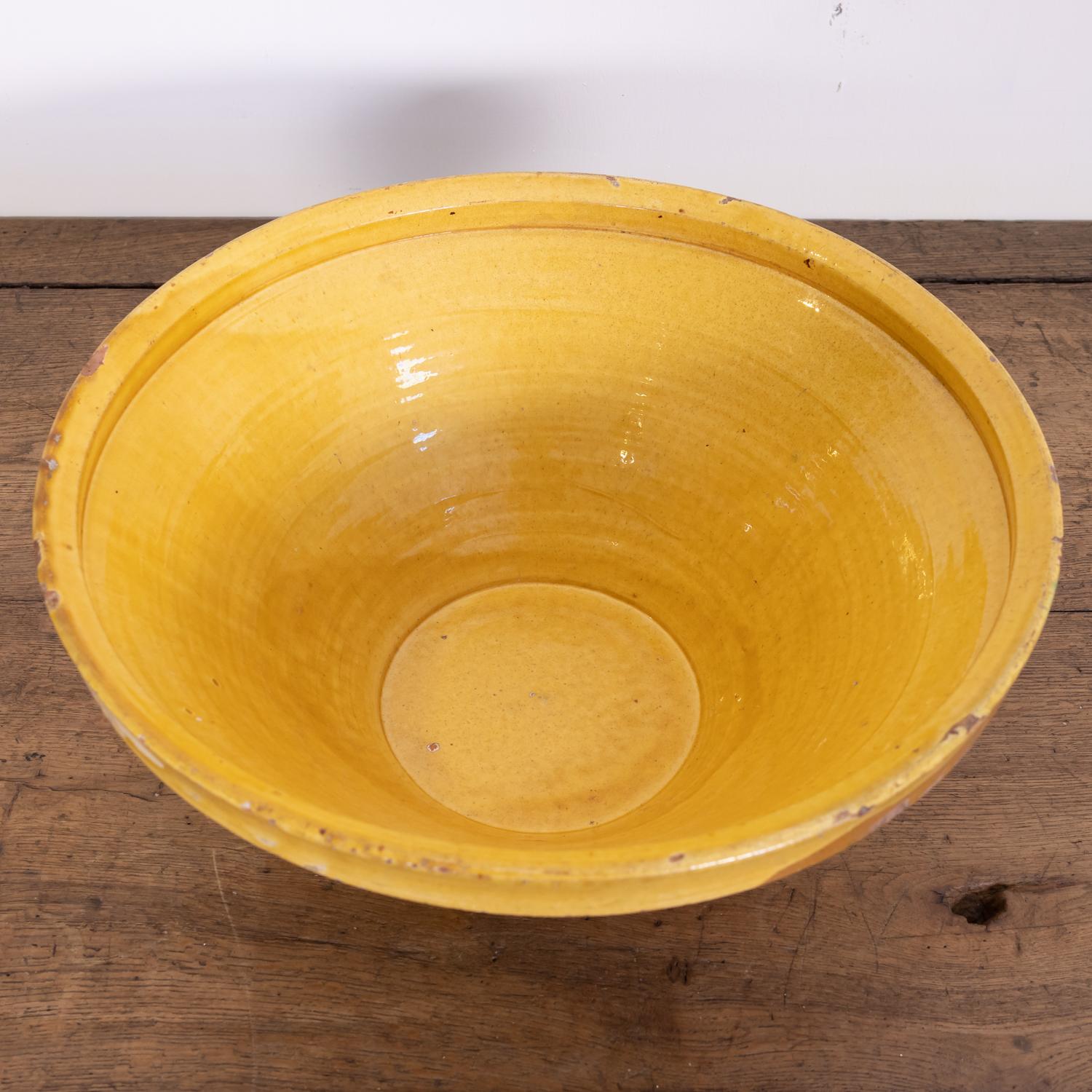 A 19th century French pancheon or dough bowl having an unglazed pale terracotta exterior and a beautiful bright yellow glaze to the interior and lip, circa 1880s. Pancheons were multipurpose terracotta kitchen bowls used during the 17th, 18th, and