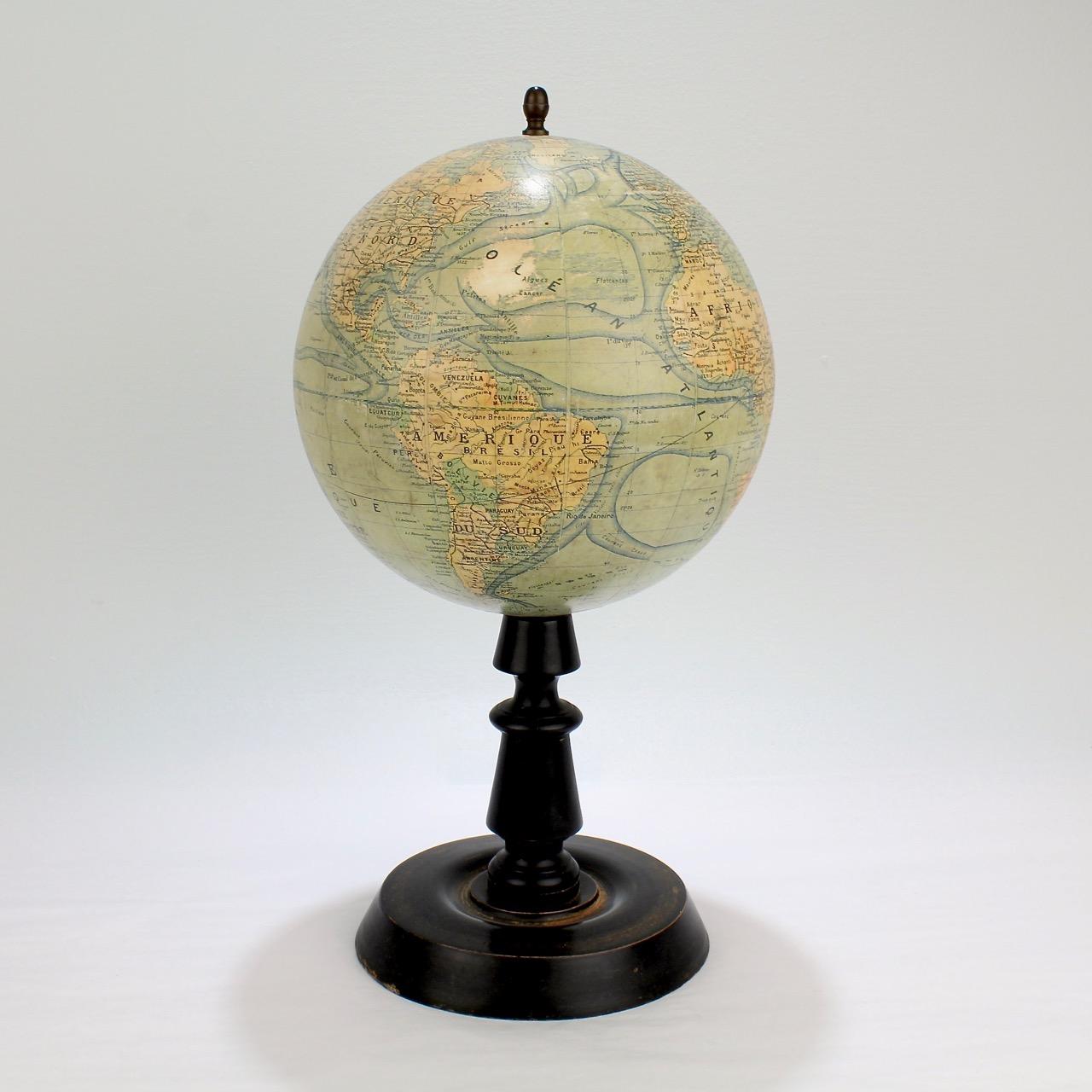 A wonderful terrestrial globe on an ebonized, turned wooden stand with a brass finial.

With 12 gores and 2 polar caps that depict the world's continents, oceans, and major currents. 

Marked for J. Forest Editor and for Paris.

Measures: Height ca.