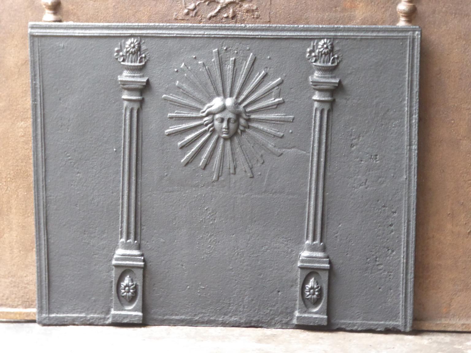 19th century French neoclassical fireback. The sun is symbol for the French King Louis XIV, called the Sun King. The sun is flanked by two pillars of freedom, which represent one of the three values of the French Revolution.

The fireback is made