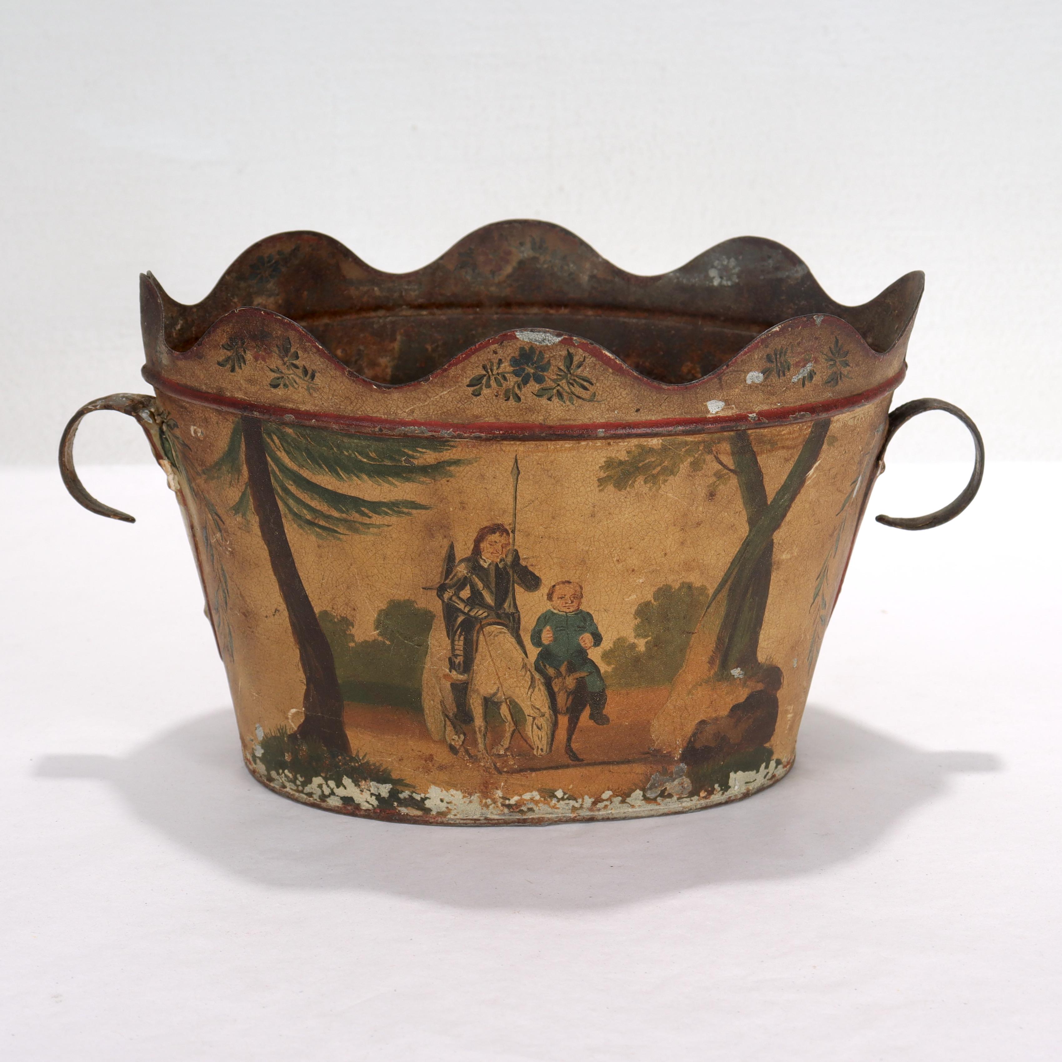 A fine antique Toleware cachepot or planter.

Decorated to both sides with a scene of Don Quixote and his companion Sancho riding atop a horse and donkey respectively

With two small curved handles, one of which appears to have been repaired.