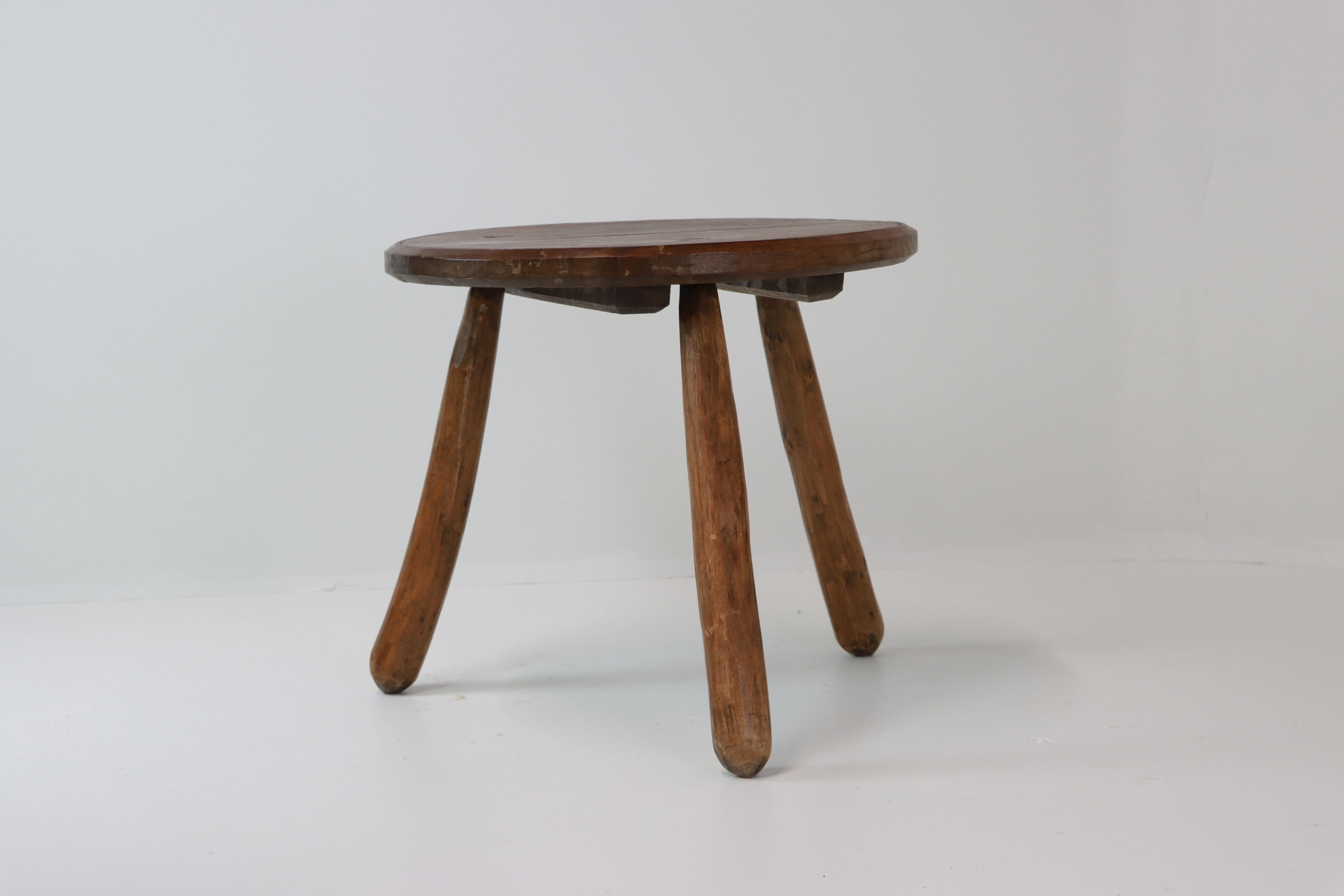 A charming French Provincial hand hewn fruitwood tripod stool/low table, with turned and splayed hardwood legs mortised through the seat. The circular seat shows off the warm, timeworn patina that only time and use can achieve. Although this was