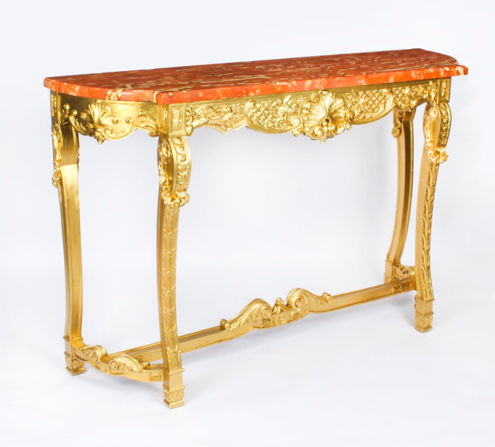 Il s'agit d'une monumentale et élégante console française en bois doré sculpté de style Louis XVIII avec miroir Trumeau assorti, datant d'environ 1820.

La console à plateau en marbre, en bois doré magnifiquement sculpté, présente un plateau en