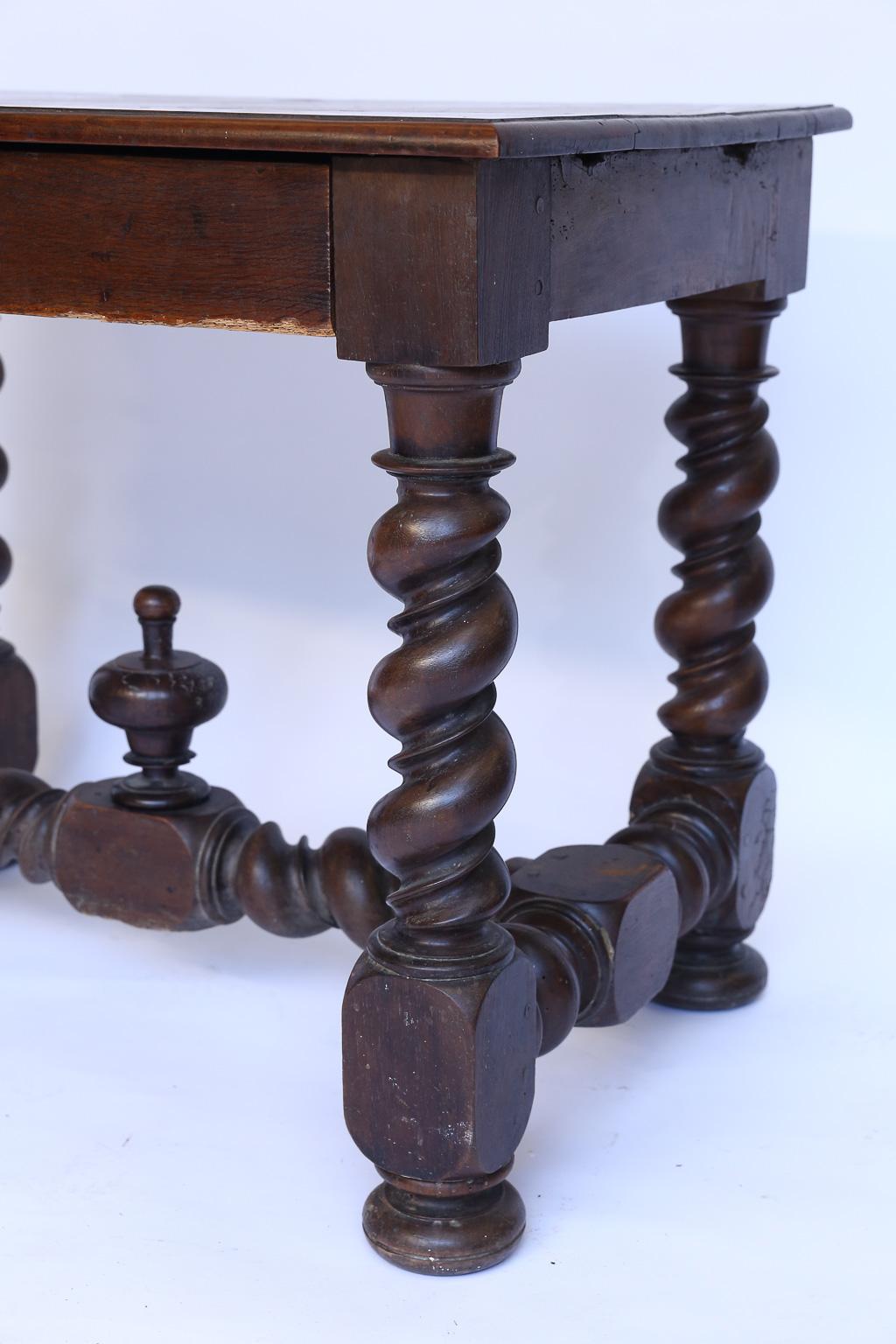 This is an antique French turned leg table with one drawer. Standing on four turned legs with an ornamental trestle, the table is strong and sturdy. The drawer has a single iron pull. Perfect for a side or end table with the drawer for storage.