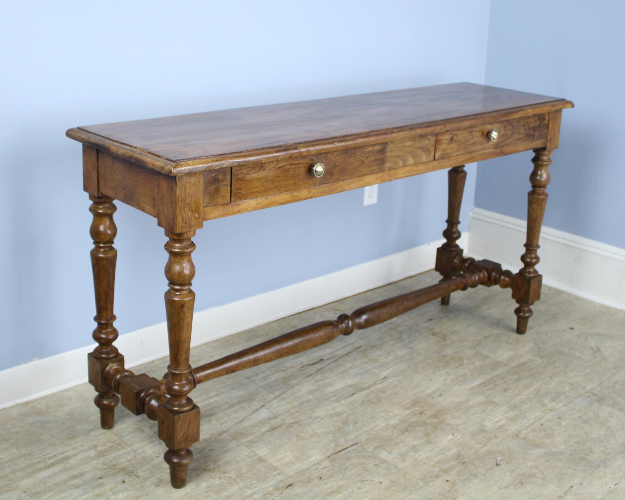 A splendid turned leg server, console, or sideboard in polished oak. The turned stretcher support enhances the look. Two wide drawers add a note of utility. This piece would be right in the front hall, but its modest depth of 17.5