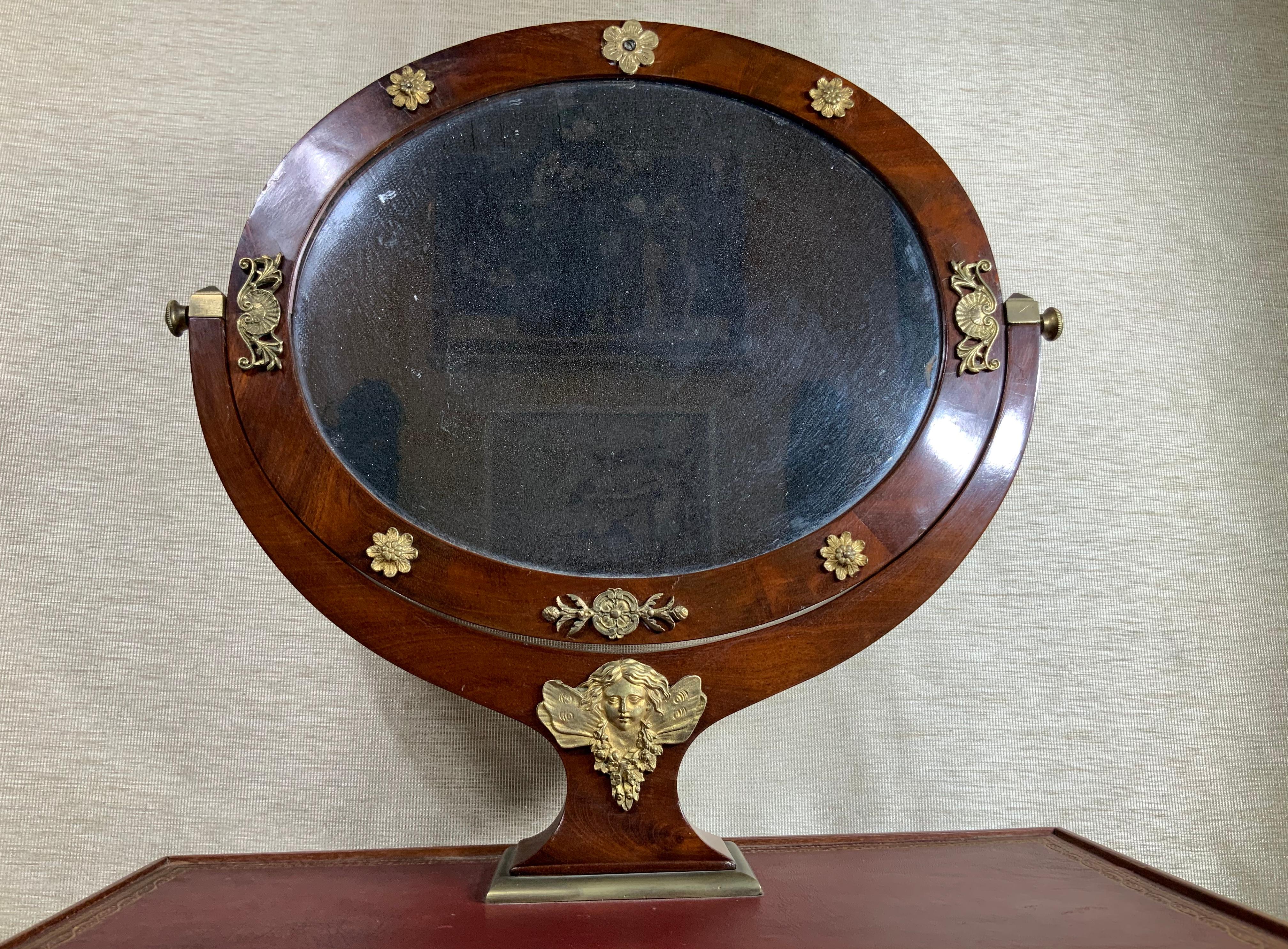 Elegant petite French vanity made of wood cover with leather top beautiful veneer and remarkable bronze accent decoration original color finish.
Beautiful oval shape frosted original mirror, hey single drawer with walking keylock. Four straight