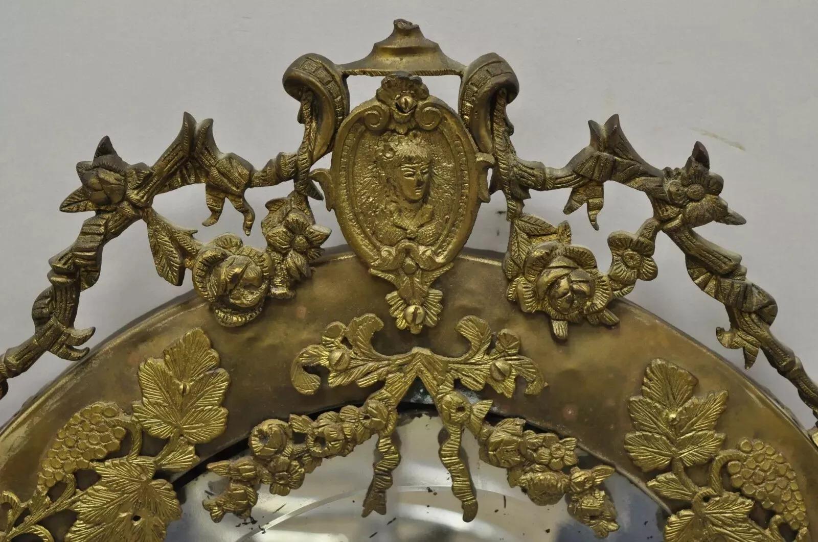 Antique French Victorian Brass Frame Bronze Ormolu Oval Beveled Glass Mirror. Item features a patinated brass frame, ornate bronze ormolu, oval beveled glass, very nice antique item. Circa Late 19th Century. Measurements: 32