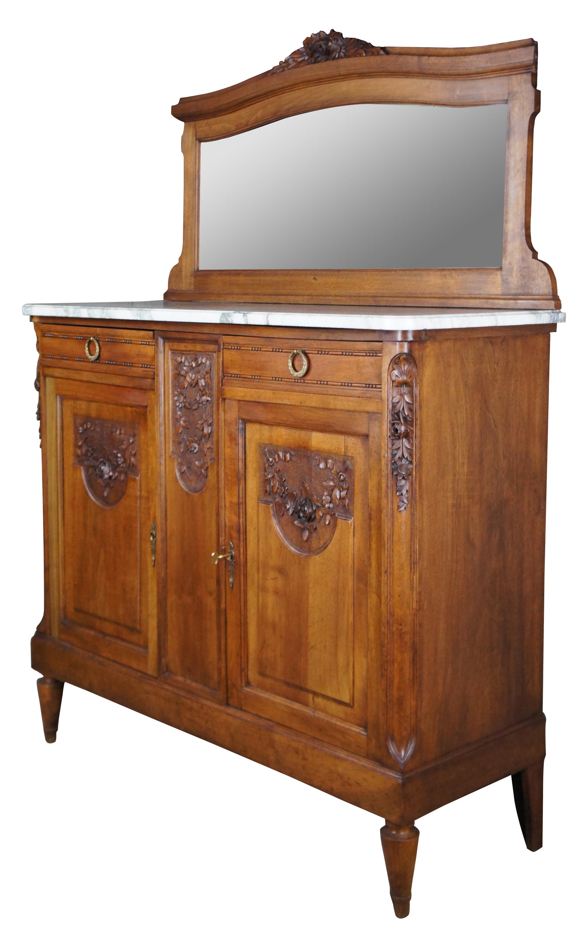 Antique Victorian era sideboard, server or bar back, circa 1890s. Made from walnut with beautiful foliate carvings, a white marble top and serpentine backsplash with glass mirror. Features two drawers with beaded carving and neoclassical brass
