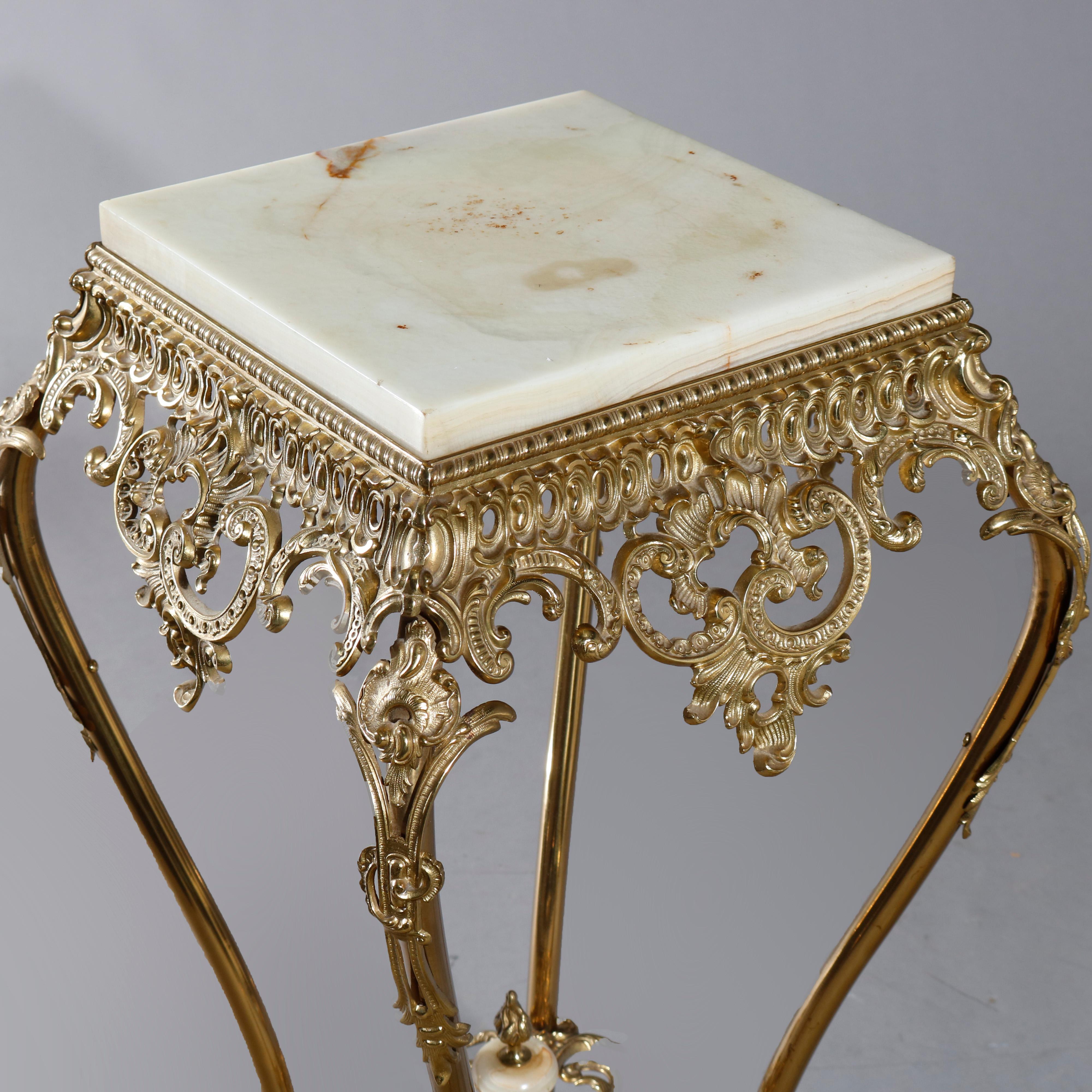 An antique French fern display stand offers gilt bronze frame with onyx plate having pierced scroll, foliate and gadroon surround raised on cabriole legs with pierced foliate stretcher and central onyx finial, circa 1890

Measures: 33
