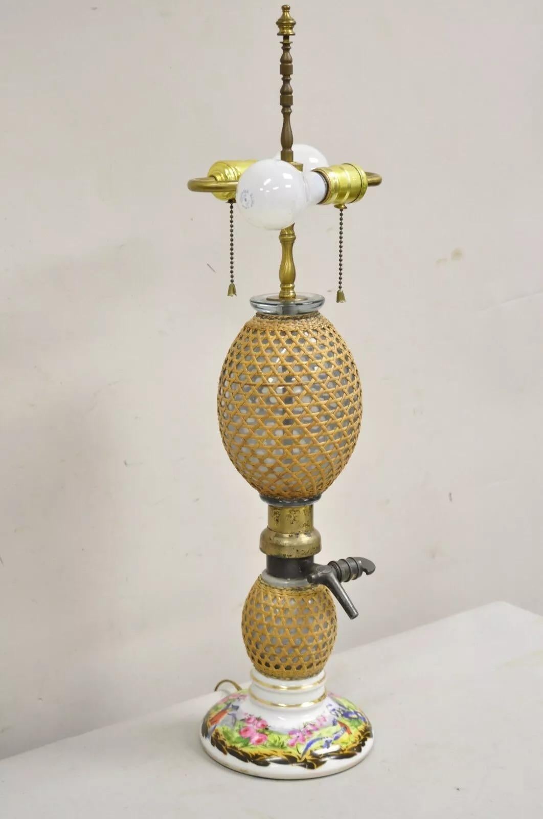Ancienne lampe de table victorienne transformée en bouteille d'eau de Seltz en verre soufflé, enveloppée de rotin, avec base peinte à la main par Briet, Paris. Circa Early 20th Century. Dimensions : 27,5