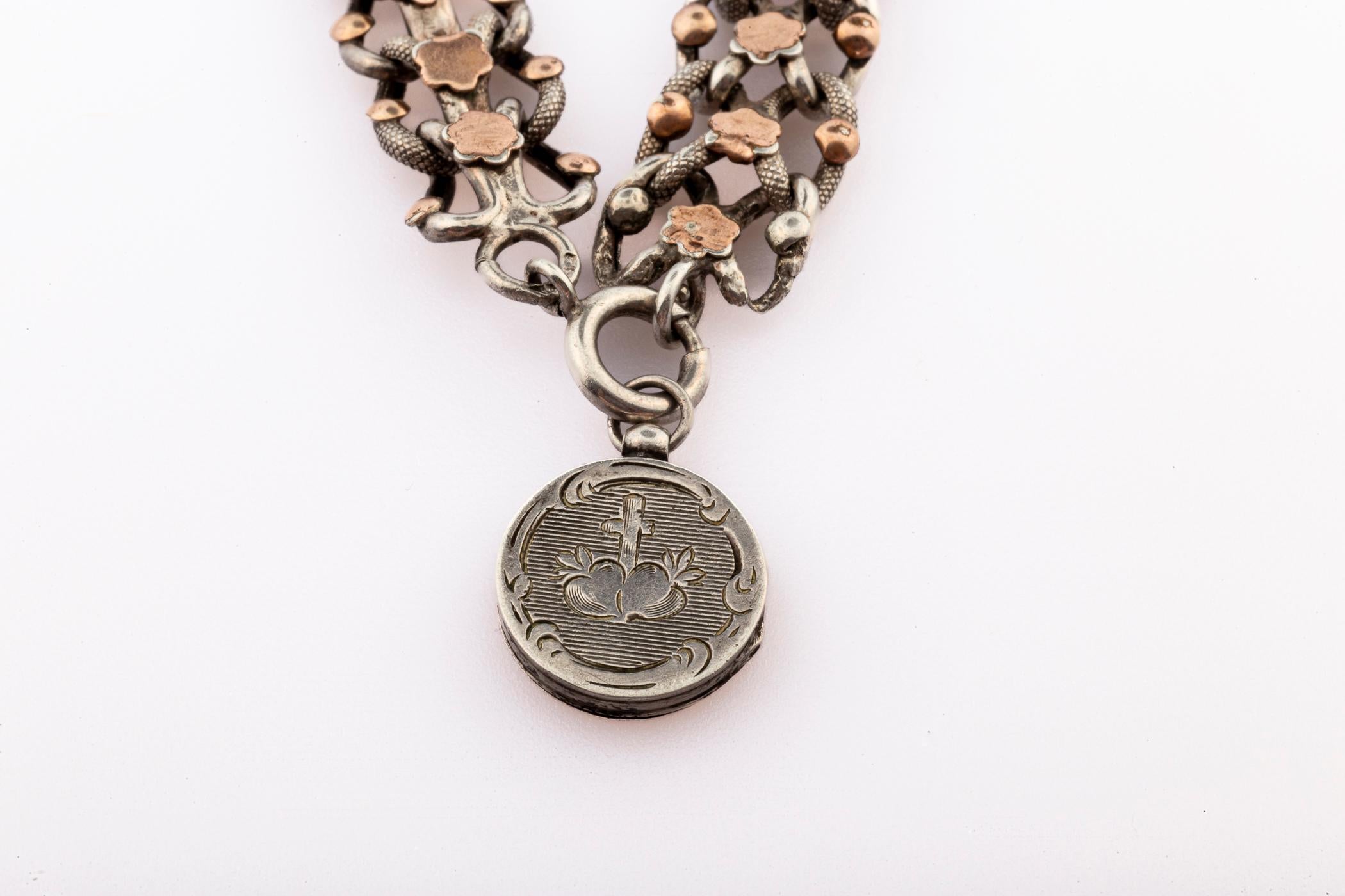 Antike Französisch viktorianischen Ära Silber und Rose Gold Armband mit Geheimnis Medaillon Charme
Der Charme ist aus Silber und hat einen Wildschweinkopf Punzierung. Auf der Vorderseite sind ein Kreuz und die durchbohrten Herzen von Maria und Jesus
