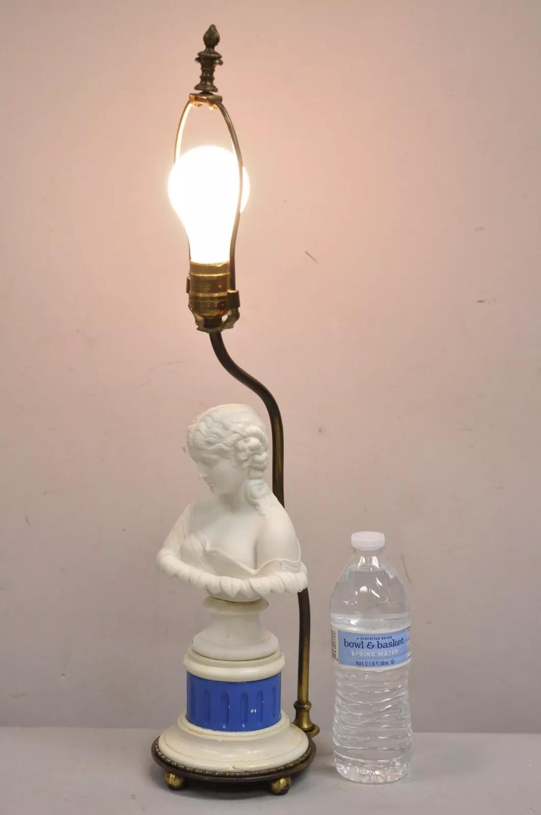 Ancienne petite lampe de table de boudoir en porcelaine blanche et bleue à buste de femme et montures en laiton. Circa Early 20th Century. Dimensions : 23,5
