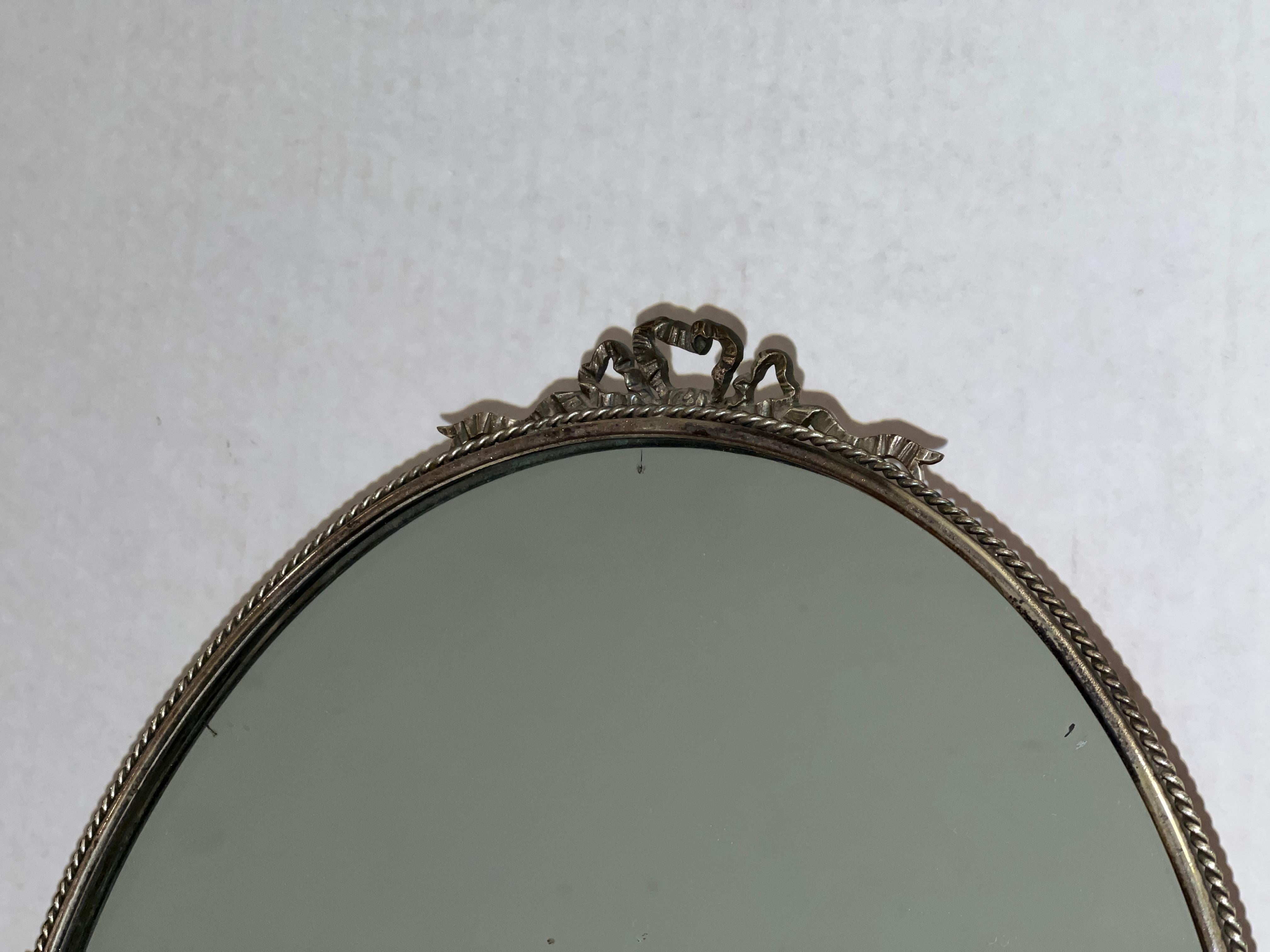 An elegant antique French vintage silver-plated oval tilt-back table vanity mirror.