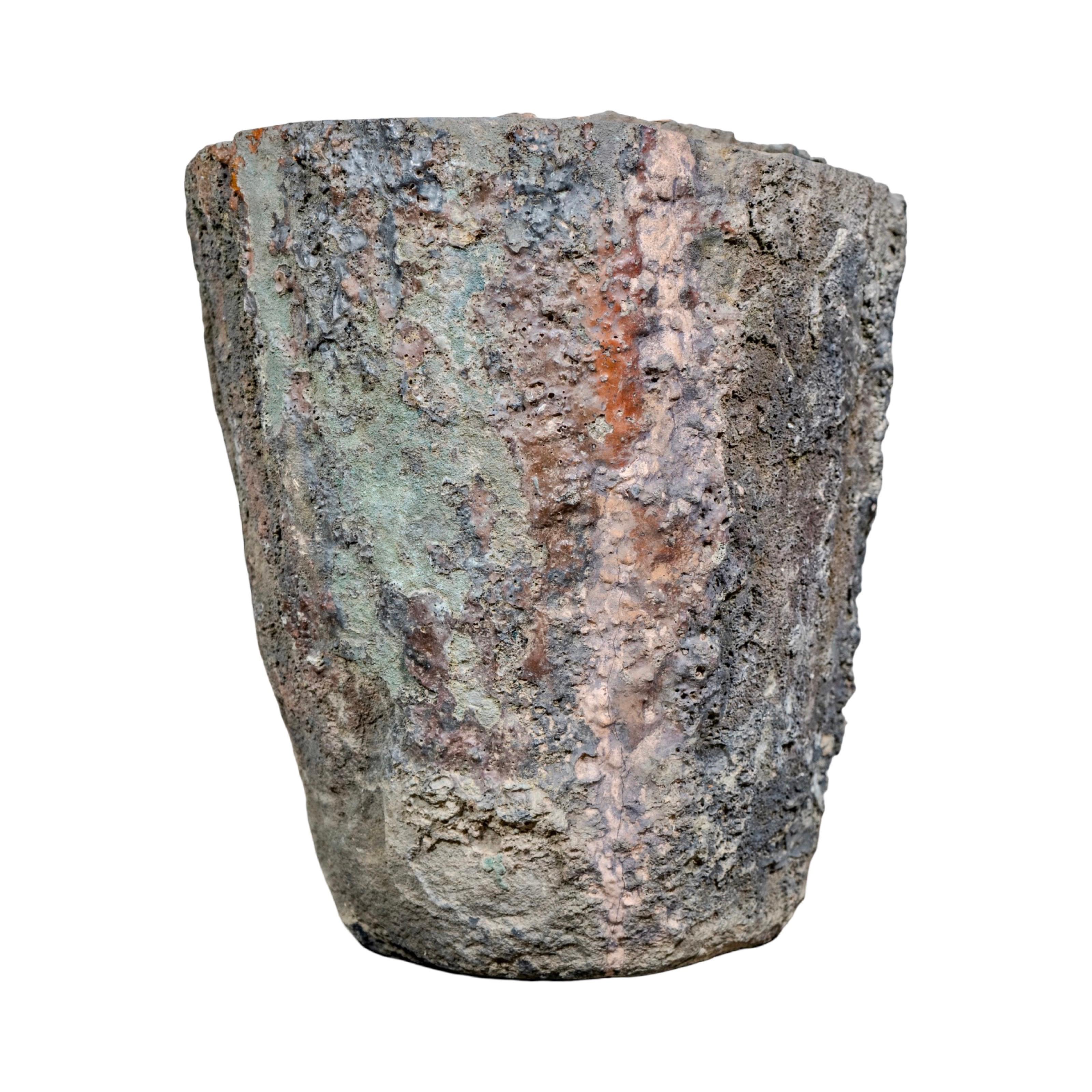 Ancienne et récupérée en France au XVIIIe siècle, cette jardinière est taillée dans une pierre de lave volcanique naturelle. Sa surface rugueuse présente de riches teintes minérales vertes, rouges et noires, avec une texture usée par le temps qui