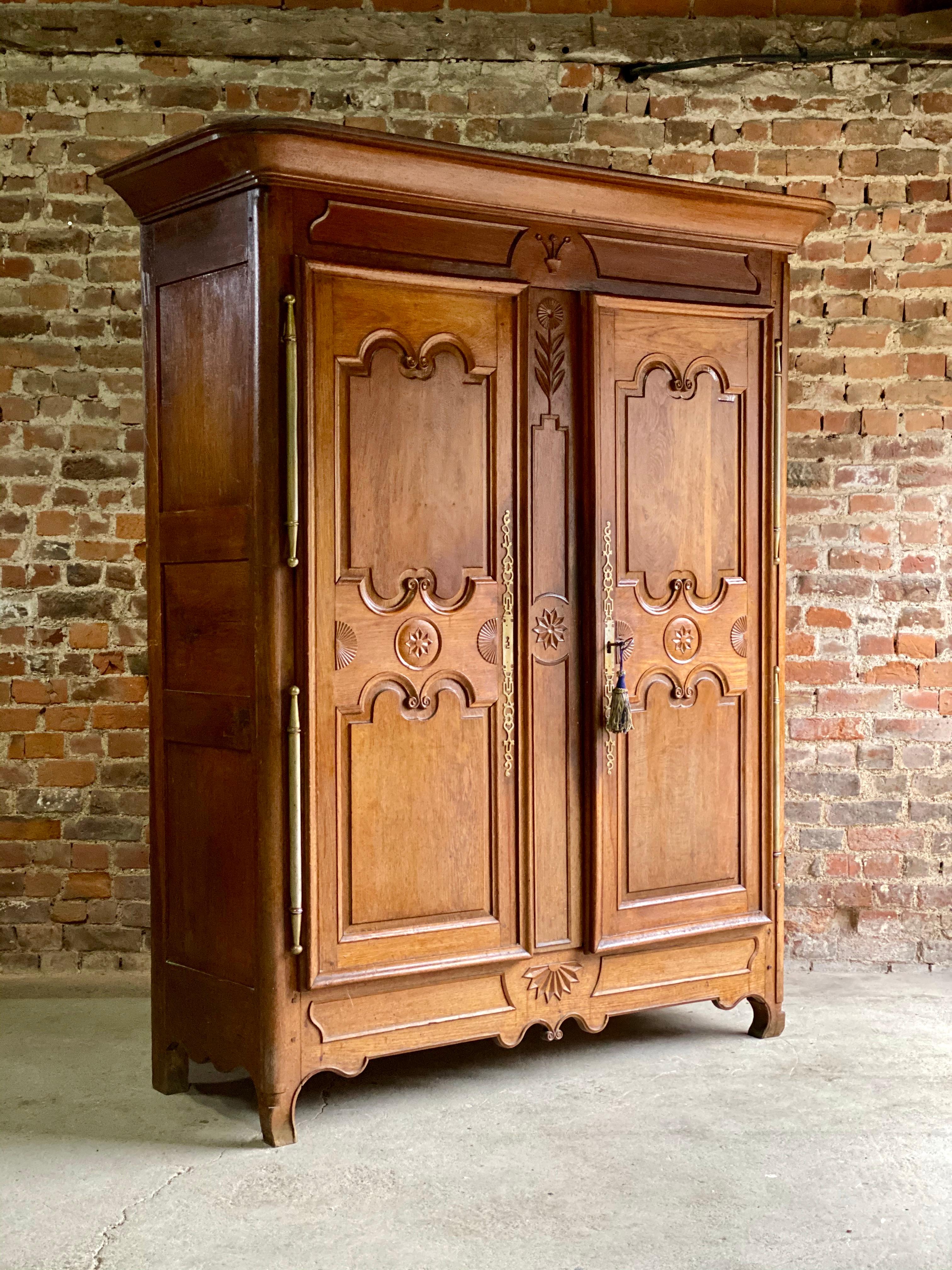 Magnificent mid-19th century Napoleon III Walnut continental armoire or cupboard circa 1850, the corniced top above two central panelled doors with carved decorations and applied brass escutcheons, the interior with three shelves, raised on shaped