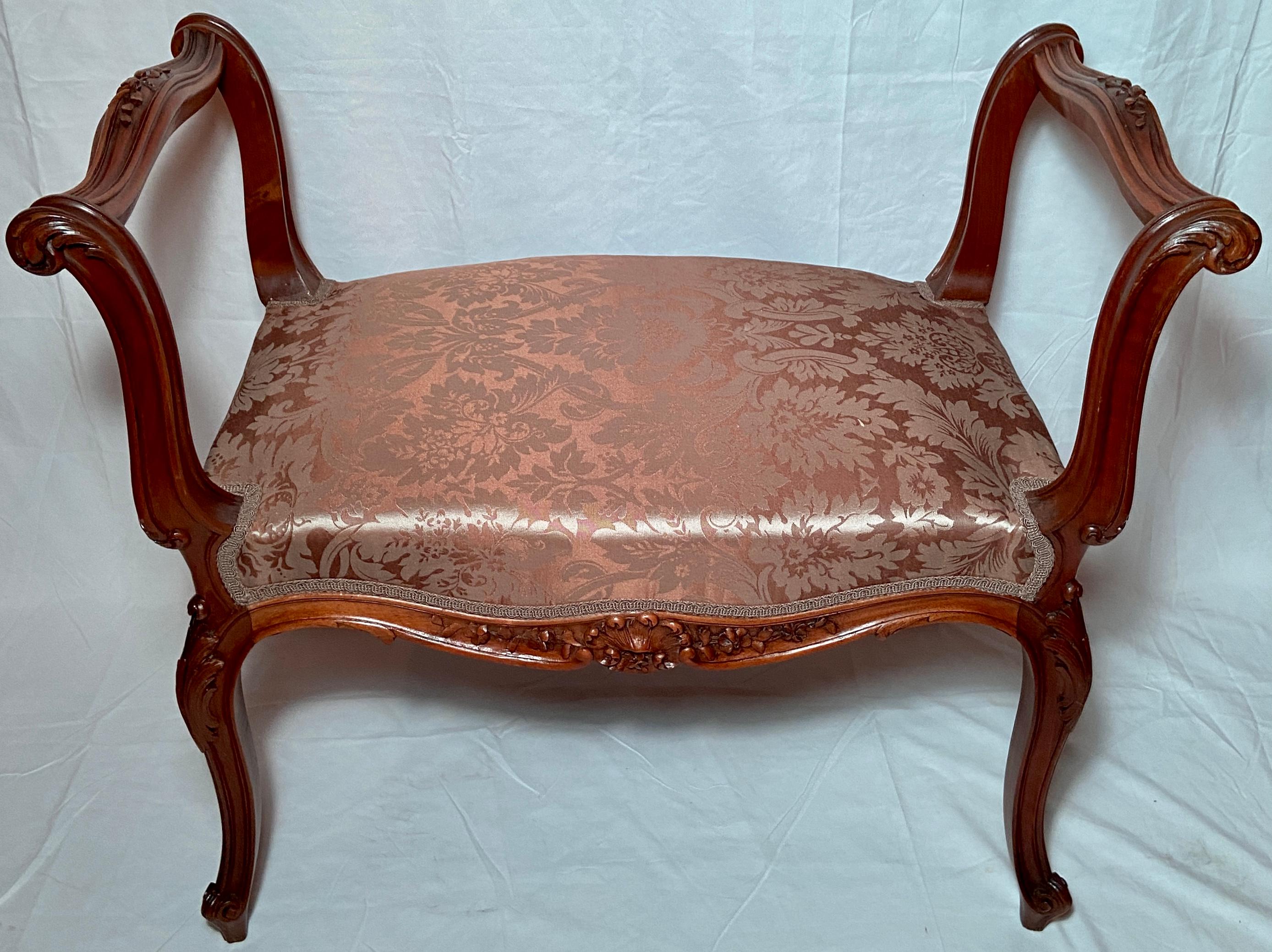 Antique French walnut bench with pink silk upholstery, circa 1880.