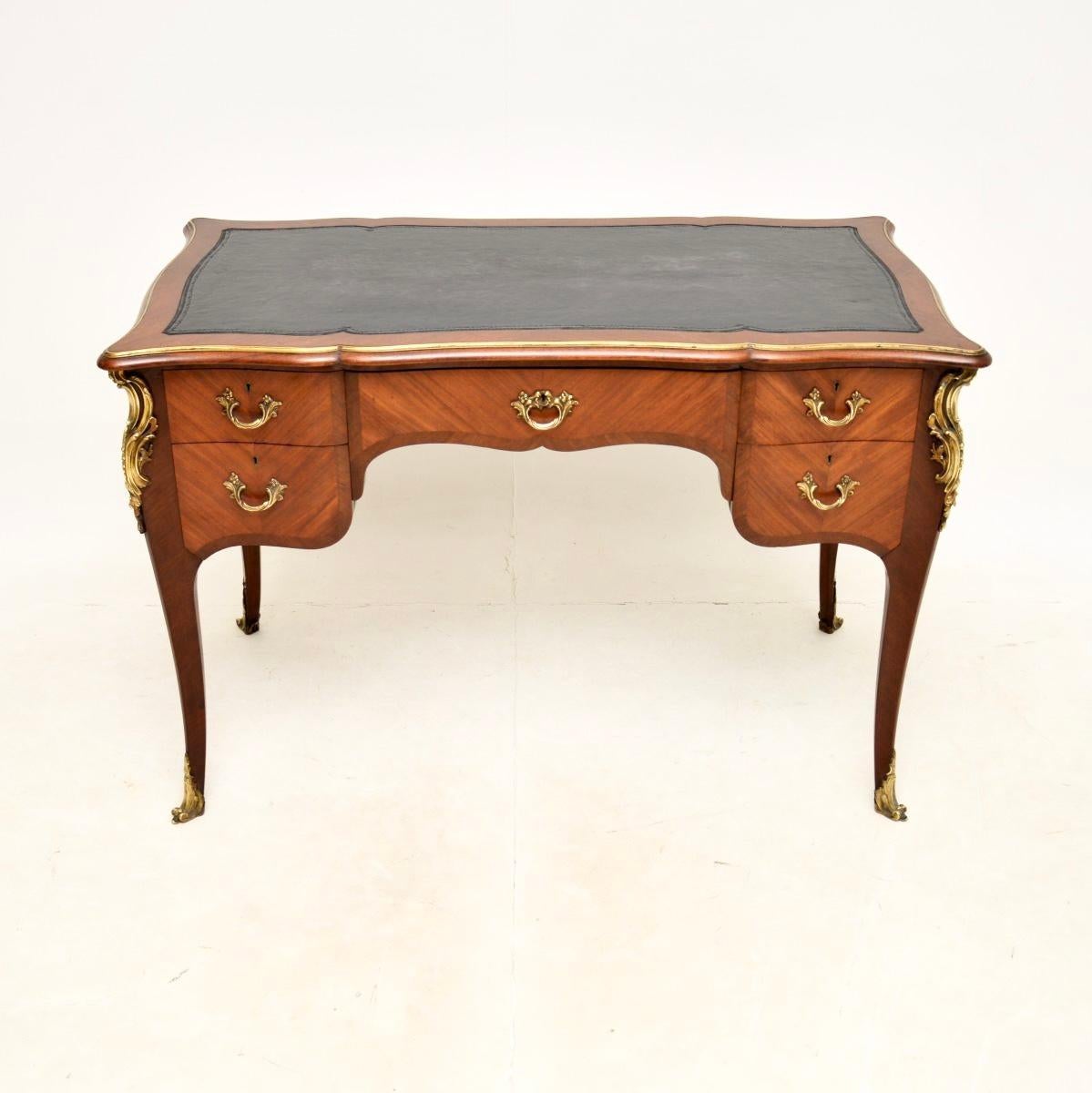 A stunning antique French walnut bureau plat desk, dating from around the 1900-1910 period.

It is of outstanding quality, this has fantastic gilt metal ormolu mounts all over, including around the top edge. All edges are nicely cross banded, this