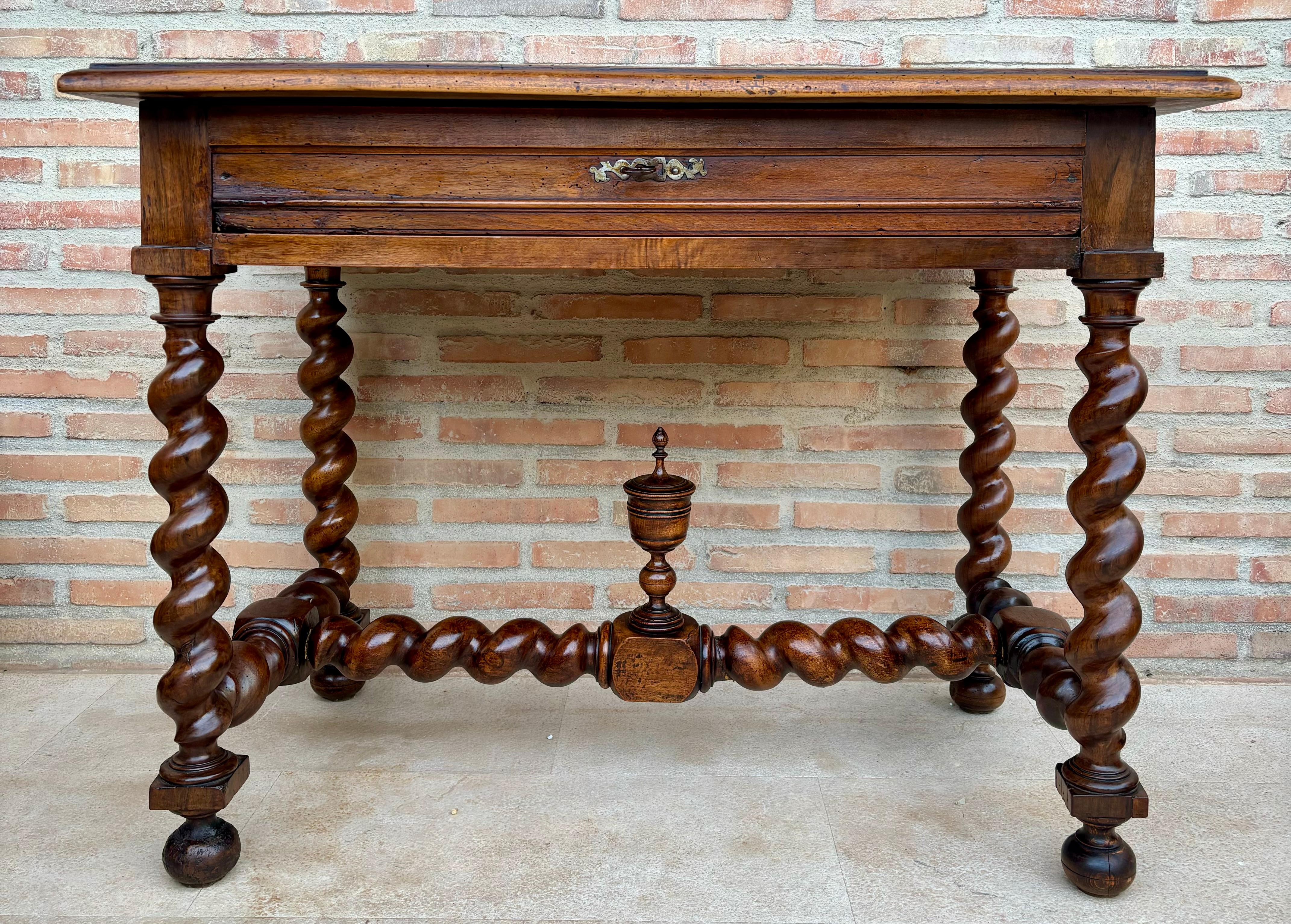 Preciosa pieza de librería de nogal que puede utilizarse como escritorio o mesa de trabajo. De robusta madera de nogal. Todas sus patas y camilla son salomónicas y tiene un cajón con su tirador de hierro, es de principios del siglo XIX.
Esta hermosa