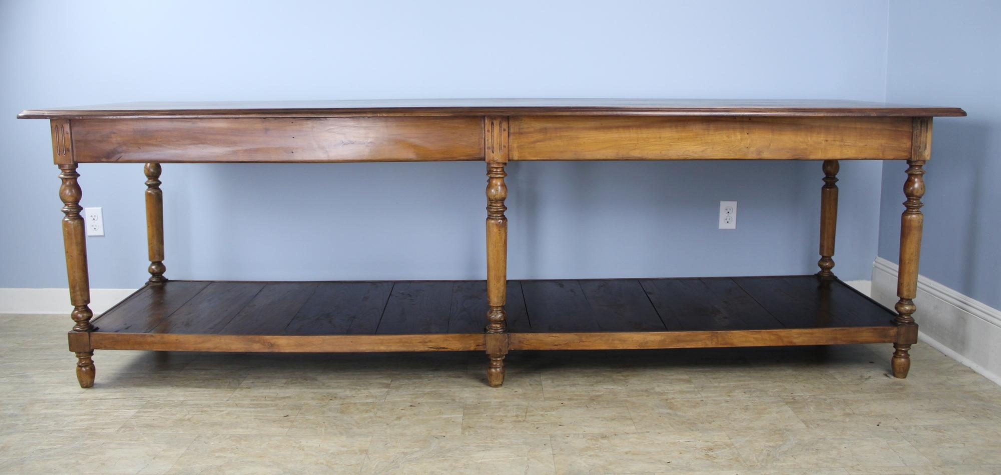 A very long, fabulous French walnut draper's table, originally for use by a tailor or seamstress. Legs have good turned detail and nice patina. Top has been refinished for a smooth clean look. Would work well as a room divider or as a kitchen